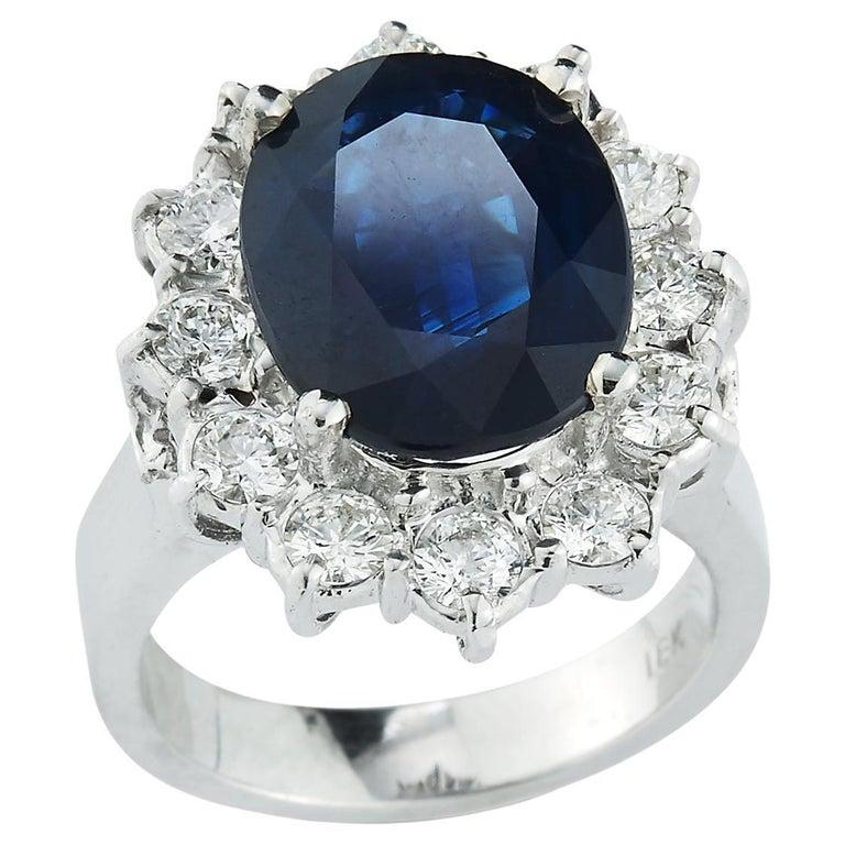 Sapphire & Diamond Ring, 1 oval cut sapphire surrounded by 12 round cut diamonds set in 18k white gold

Sapphire Weight approximately 6.75 cts 

Diamond Weight: approximately 1.80 cts 

Ring Size: 5.75

Resizable