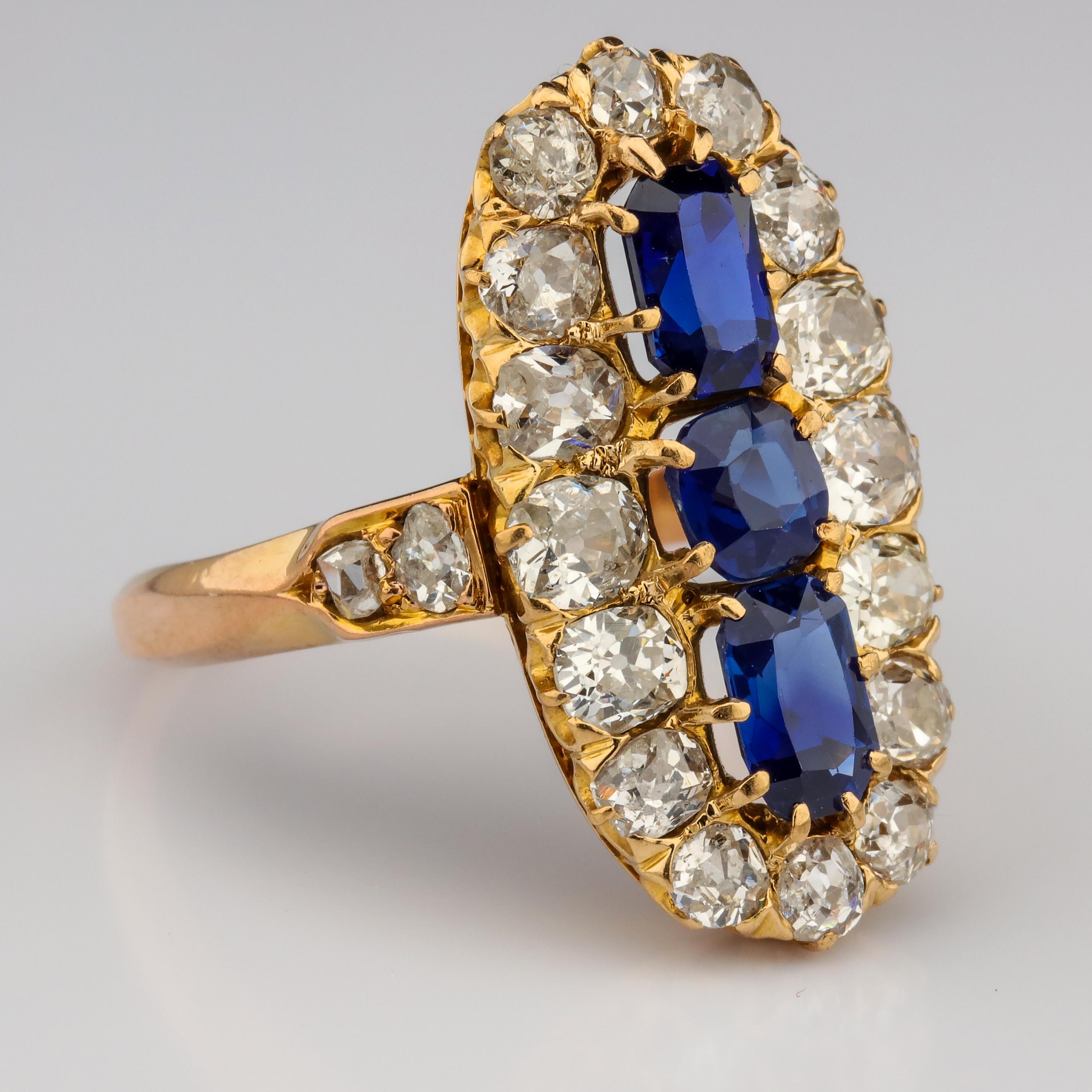A line of one cushion and two octagonal mixed-cut GIA-certified no-heat sapphires totaling approximately 2.26 carats stand out in vivid, royal-blue relief against a surround sixteen of near-colorless round, oval and cushion-cut old-mine diamonds
