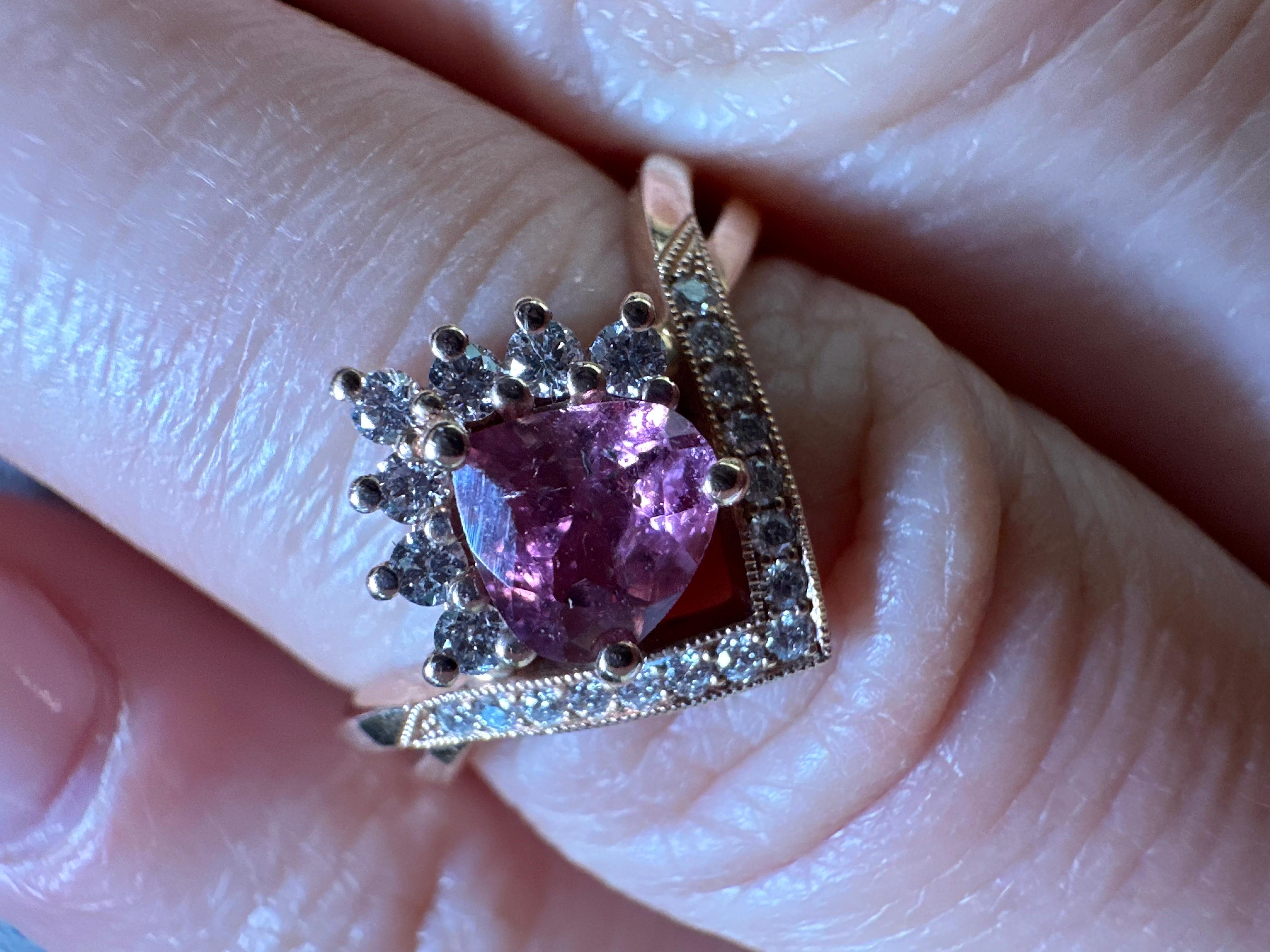 Modern engagement ring, unique from start to finish, two infinte lines go through as the circle of love for a lifetime closes, the artist made an interesting presentation with a trillion pink sapphire in the middle and diamonds in a halo, stunning!