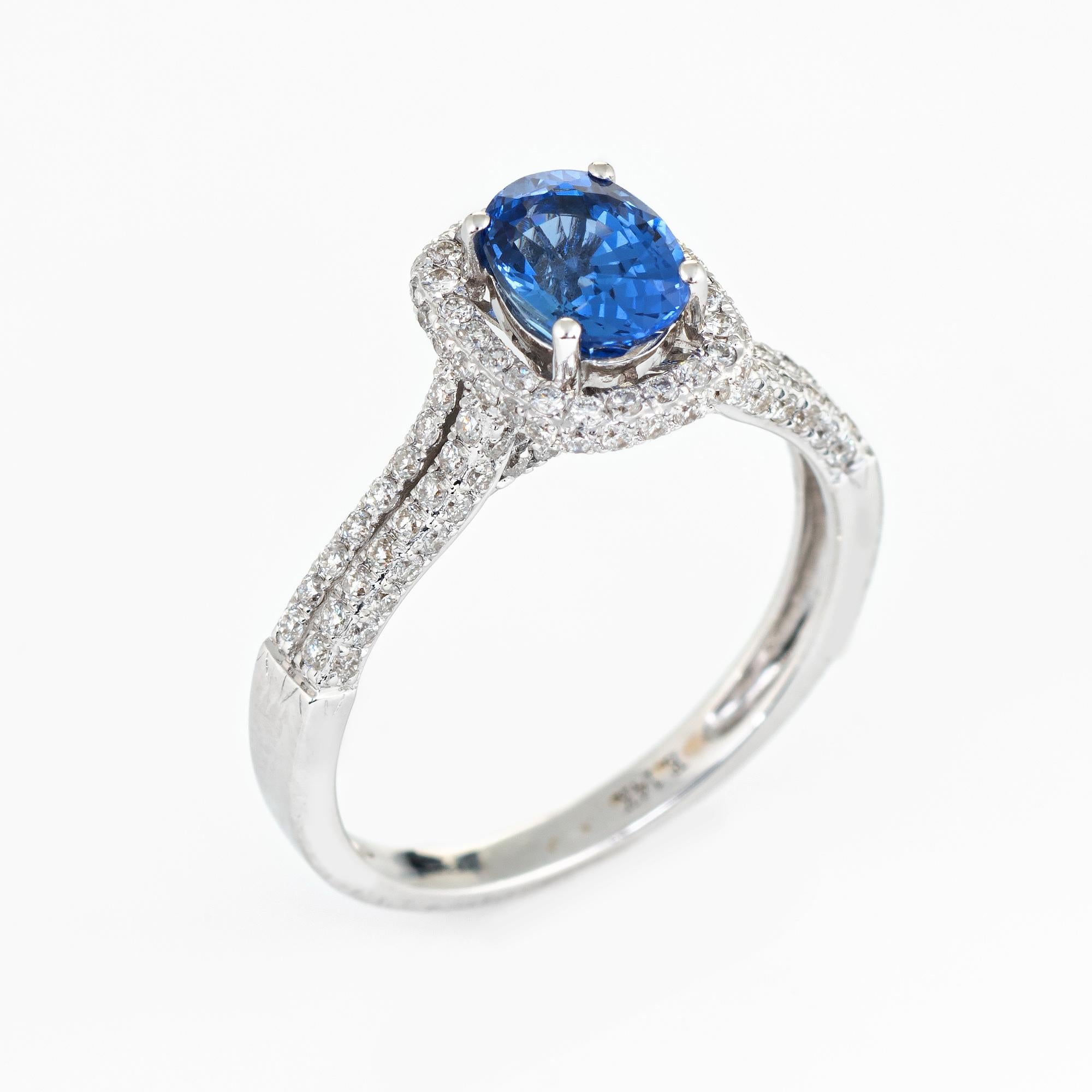 
Stylish contemporary sapphire & diamond halo ring crafted in 14 karat white gold. 

Faceted oval sapphire measures 7mm x 5.5mm (estimated at 0.75 carats). Round brilliant cut diamonds total an estimated 0.60 carats. The tanzanite is in very good