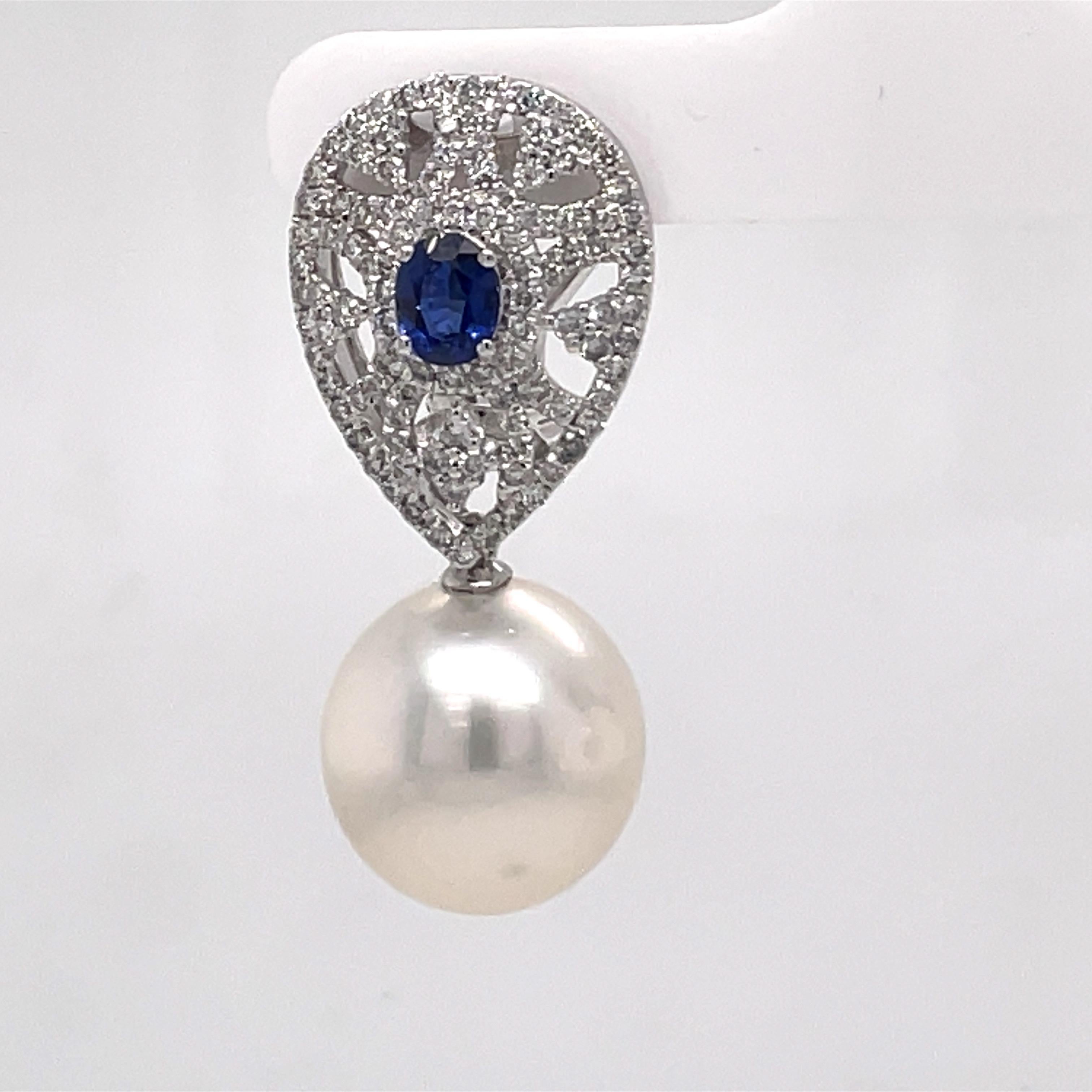 18 Karat White gold drop earrings featuring two blue Oval Cut Sapphires weighing 0.92 carats flanked with 208 round brilliants weighing 1.24 carats and two South Sea Pearls measuring 13-14 MM.
Color G-H
Clarity SI