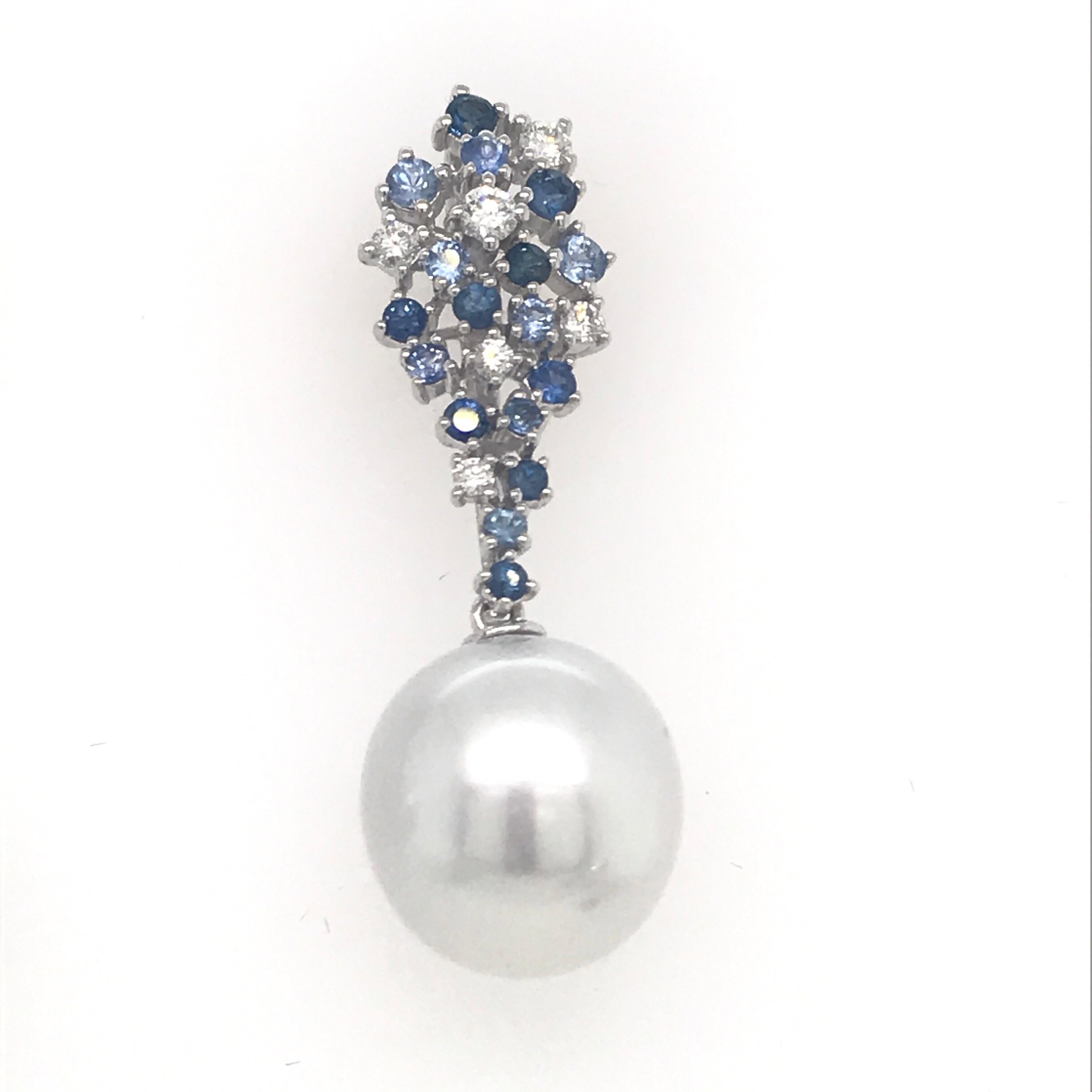 18K White gold drop earrings featuring a cluster of 34 blue sapphires weighing 1.16 carats and 12 diamonds weighing 0.34 carats with two South Sea Pearls measuring 12-13 mm. 