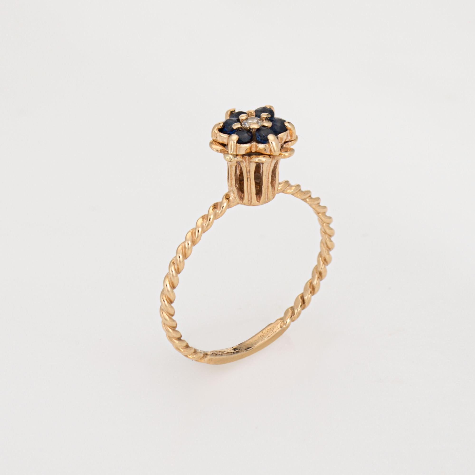 Elegante anello vintage con zaffiro e diamante a tulipano (circa anni '60-'70) realizzato in oro giallo 14 carati. 

Il diamante rotondo taglio brillante ha un peso stimato di 0,01 carati (colore L-M e purezza I1). I sei zaffiri misurano circa 1 mm