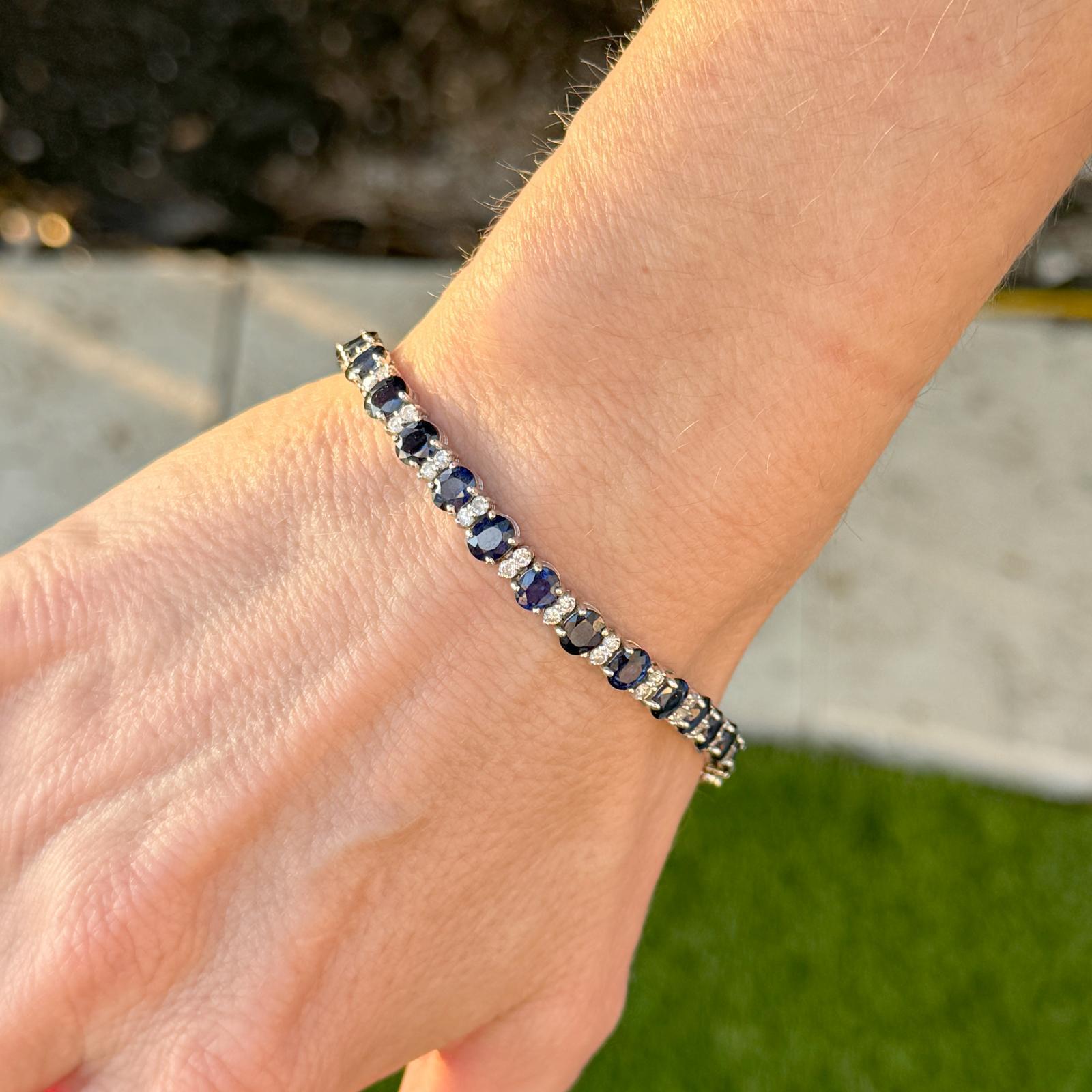 Sapphire and diamond bracelet crafted in 14 karat white gold. The bracelet features 27 natural blue sapphire gemstones weighing approximately 14 carat total weight and 54 round brilliant cut diamonds weighing approximately 1.80 carat total weight.