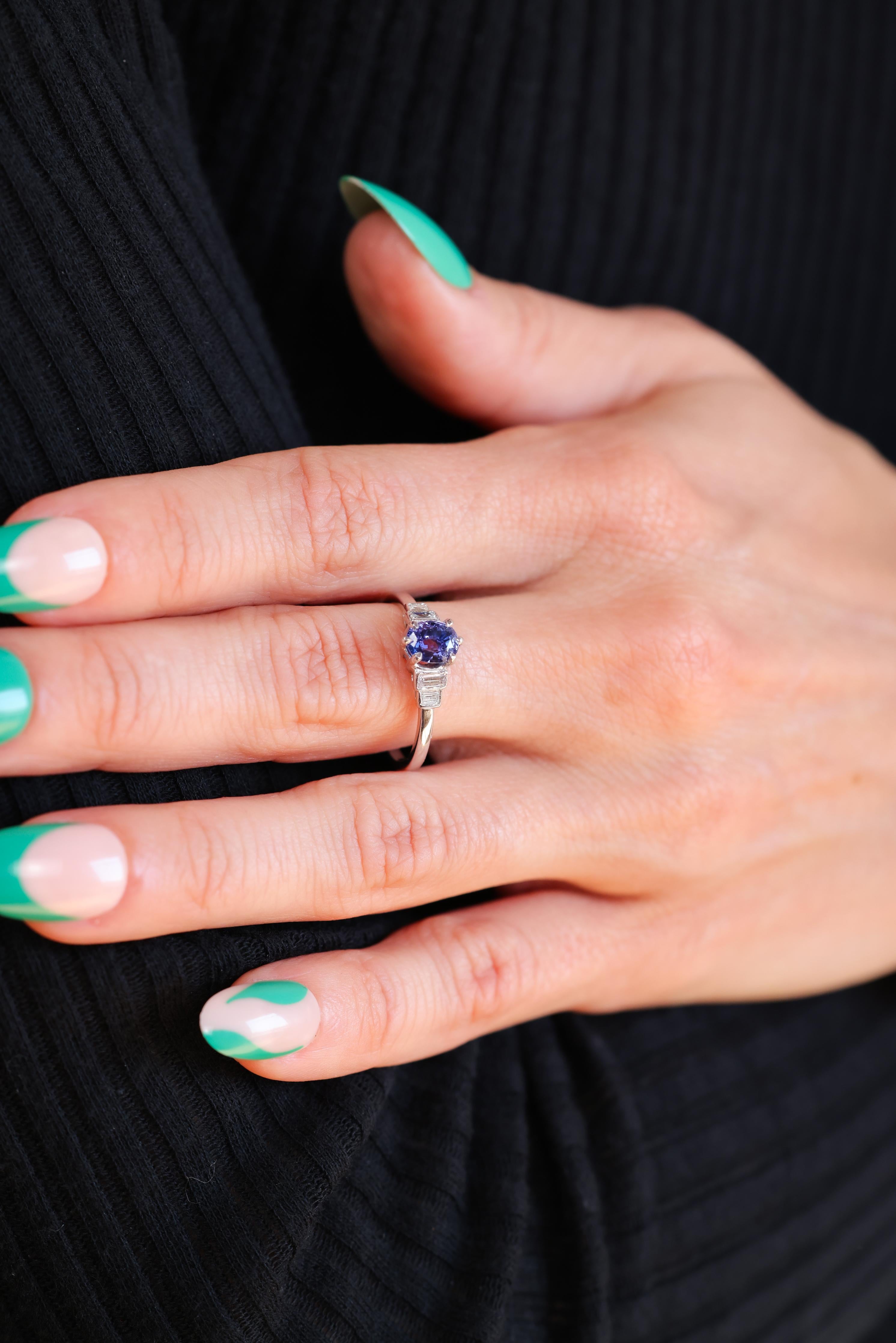 Center Stone: Blue Sapphire
Weight: 1.10 carat approximately 
Cut: Oval
Accent Stone: 4 diamonds
Cut: Emerald
Weight: 0.30 carat approximately 
Color: I-J 
Clarity: VS-SI
Metal: 18k white gold
Era: Modern
Circa: 2000s
Size: 7-3/4 and can be resized