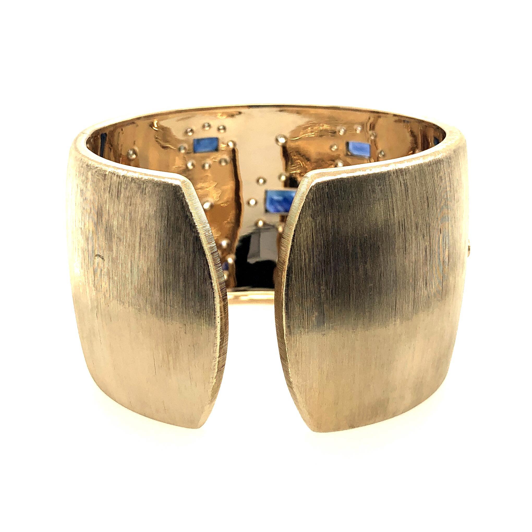 Offered here is a gorgeous sapphire and diamond cuff bangle in 18kt gold.
The cuff is extremely well made. The bangle is 18kt yellow gold ( marked 750 ITALY 2144M ). The bangle weighs 104.7 grams, measures almost 1.75” wide and 7.25” in length. The