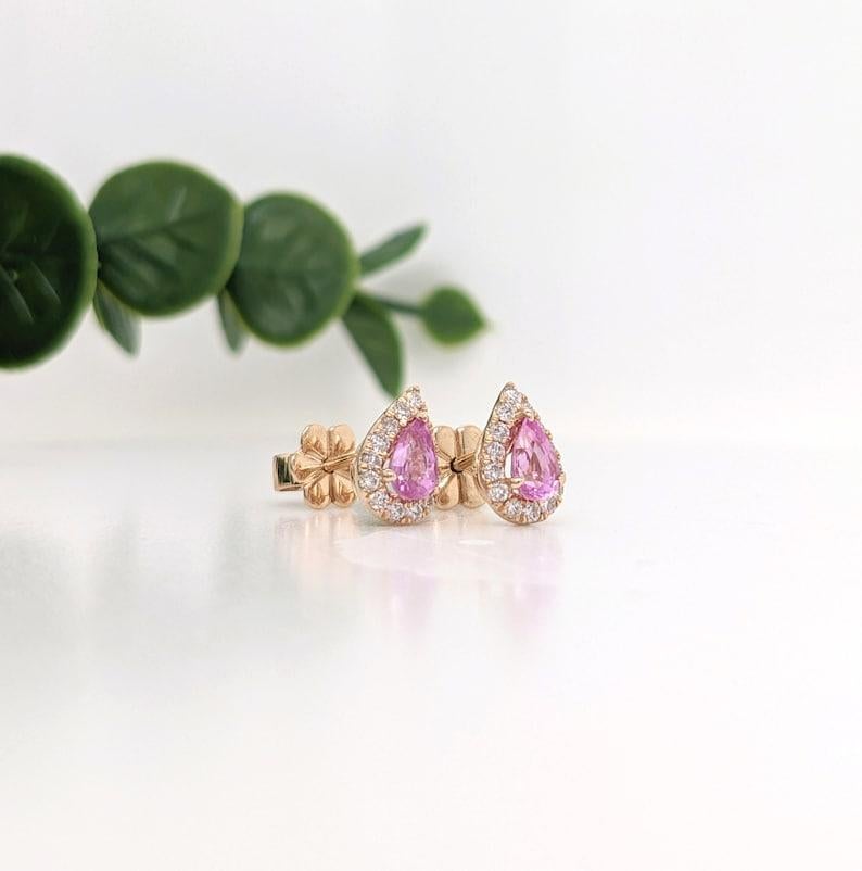 This pair of diamond halo stud earrings feature a matched pair of baby pink Sapphires. A classic earring design perfect for an eye catching engagement or anniversary. These earrings also makes a beautiful birthstone earrings for your loved