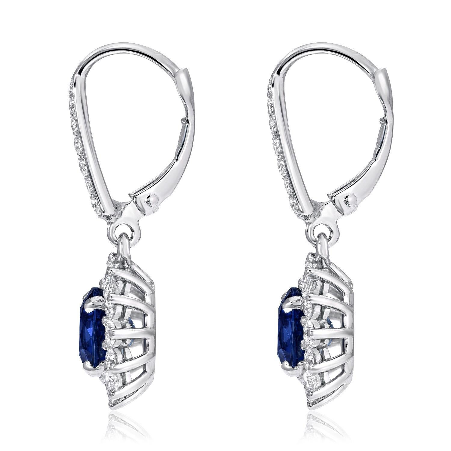 Sapphire earrings featuring a pair of round Blue Sapphires weighing a total of 3.47 carats, and adorned by a total of 1.26 carats of diamonds, in 18K white gold.
These lever back, drop Sapphire earrings are approximately 1 inch long.

Returns are