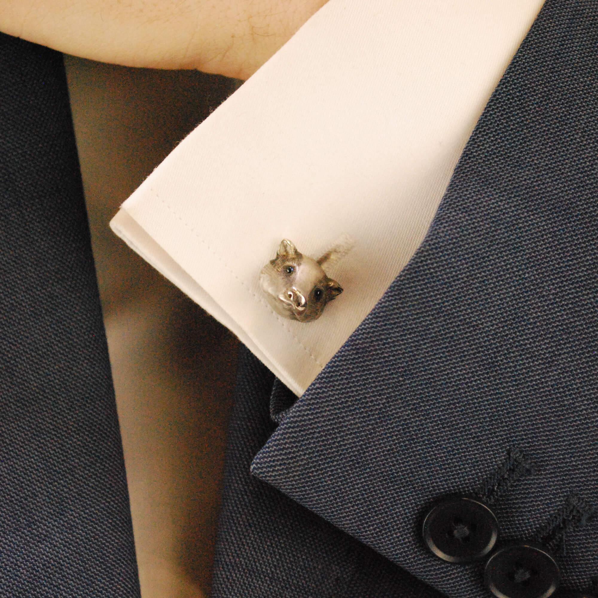 A sweet pair of sapphire eyed badger swivel back cufflinks set in 18k white gold.

Each cufflink depicts the head of a badger and is made of solid 18k white gold. Each badger is then embellished with two cabochon sapphire eyes and detailed with a