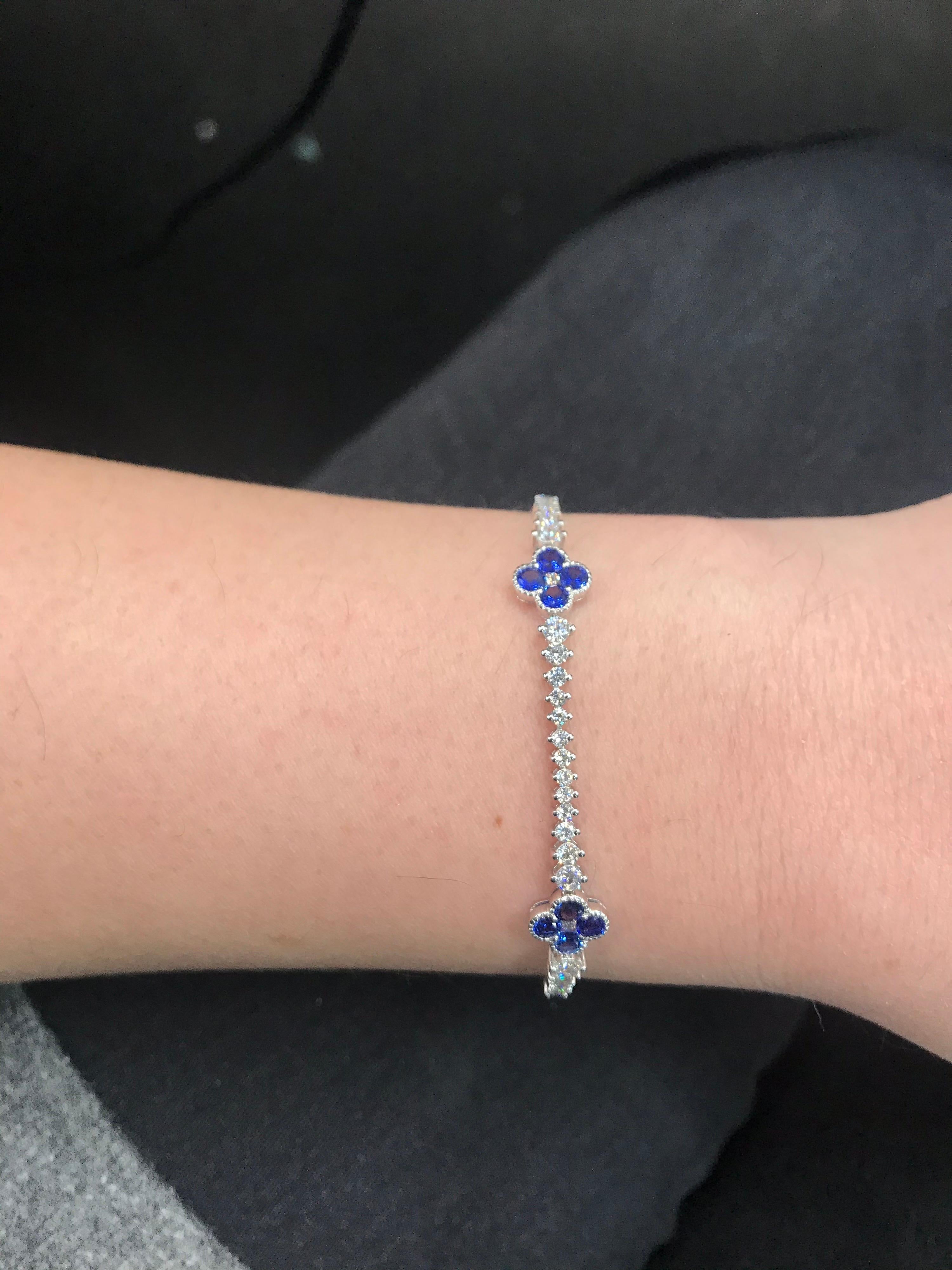 18K White gold tennis bracelet featuring give blue sapphire floral weighing 2.61 carats with graduated round brilliants weighing 2.29 carats.
Color G-H
Clarity SI