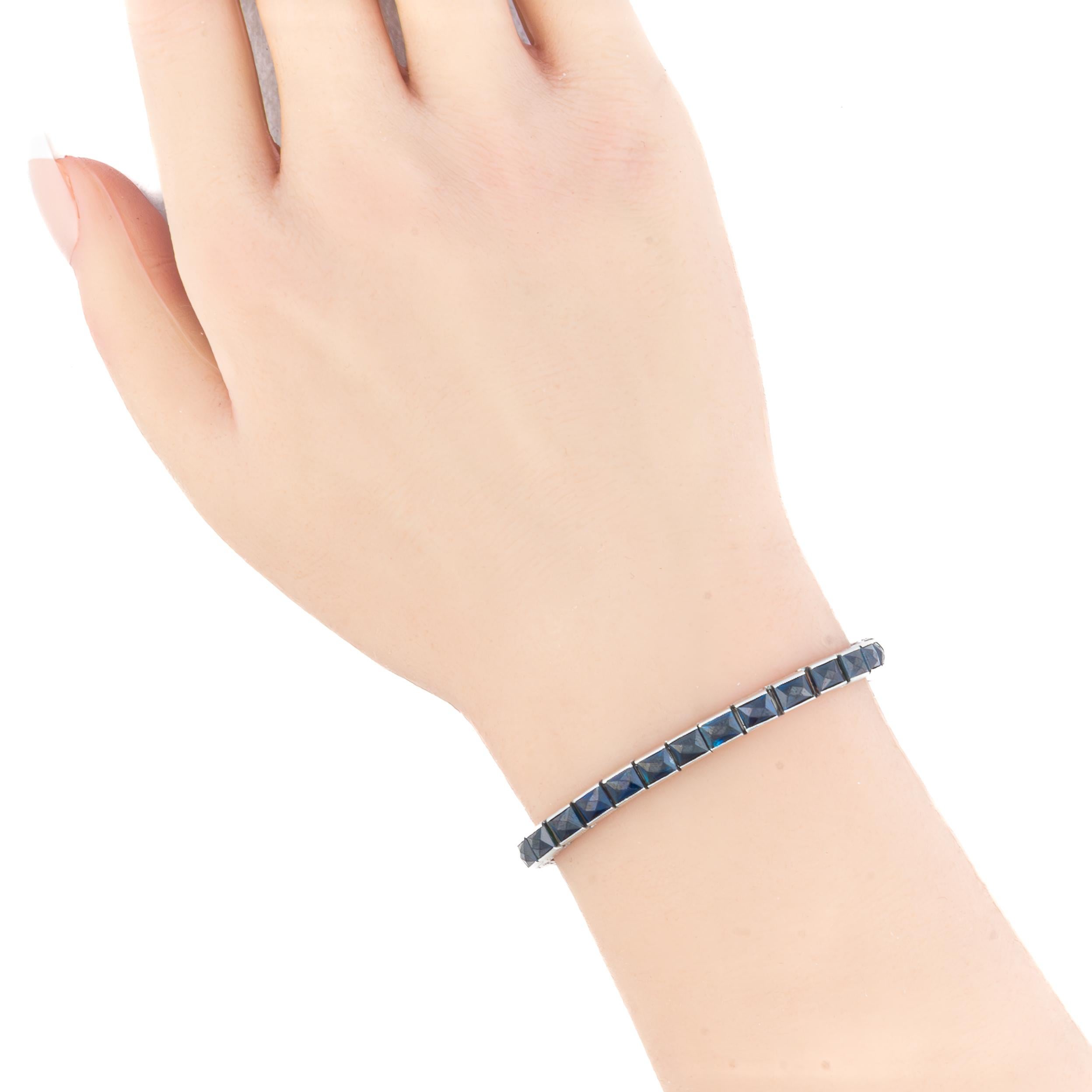 Sapphire Half Bezel Tennis Bracelet

This elegant bracelet showcases a sleek line of vibrant deep blue princess-cut sapphires, each meticulously channel-set in luminous platinum. The sapphires exhibit rich, well-matched color and precision-cut