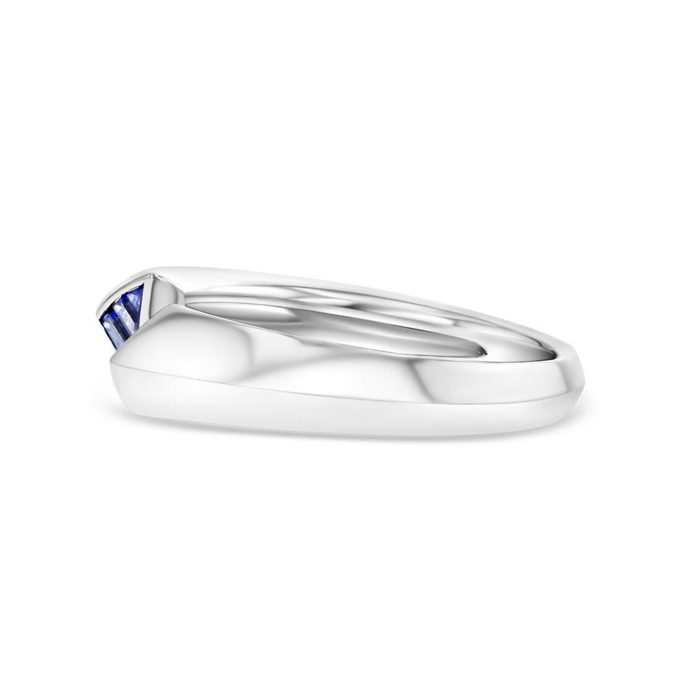 This contemporary piece is composed of 6 baguette cut sapphires and 18 karat white gold. Its knife edge style and open ended band, which leads to two opposing triangles of sapphires, allows for a unique geometric design and overall creates a sleek