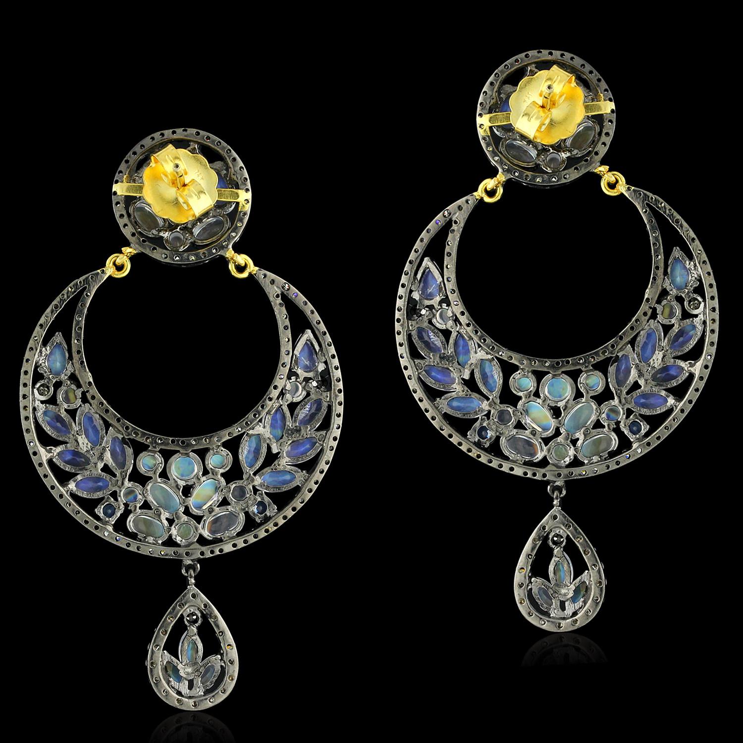 These stunning half moon shaped earrings feature a beautiful blend of sapphires and moonstones, accented with sparkling pave diamonds. The combination of the rich blue sapphires and the ethereal white moonstones creates a mesmerizing and elegant