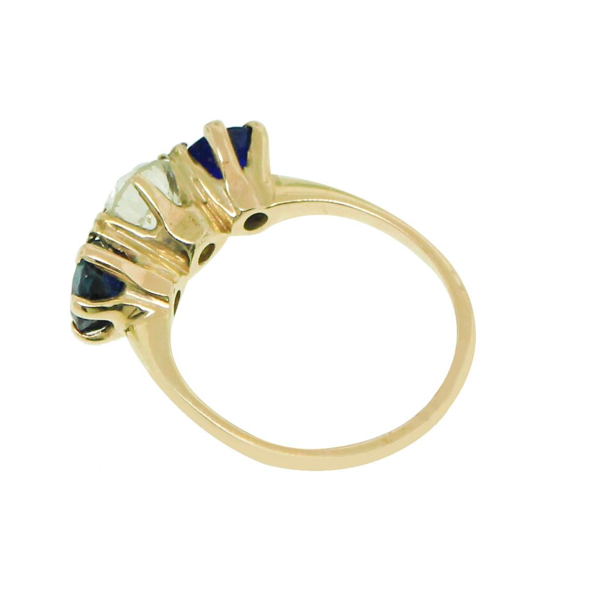 Discover timeless elegance with this stunning 14-karat ring featuring a trio of exquisite gemstones and diamonds. The centerpiece is an old euro cut diamond, flanked by two sparkling sapphires. Each stone is carefully set in a classic design that