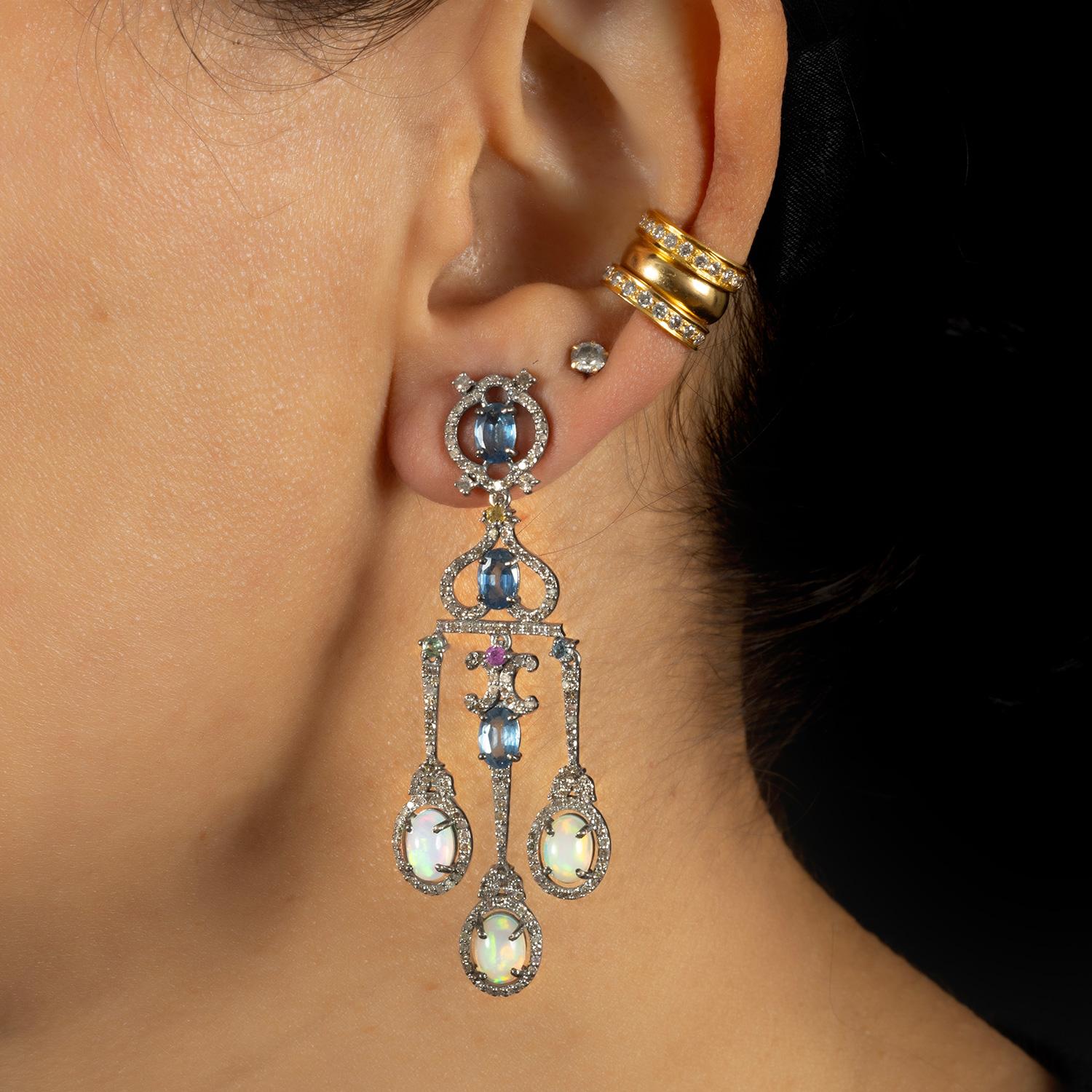 Intricately set with consciously sourced sapphire (4.15 carat), opal (3.60 carat), single cut diamonds (2.8 carat) on a mix of silver and 14kt gold; with an elegant fluid movement to them. Notice the two small ruby stone detailing in the