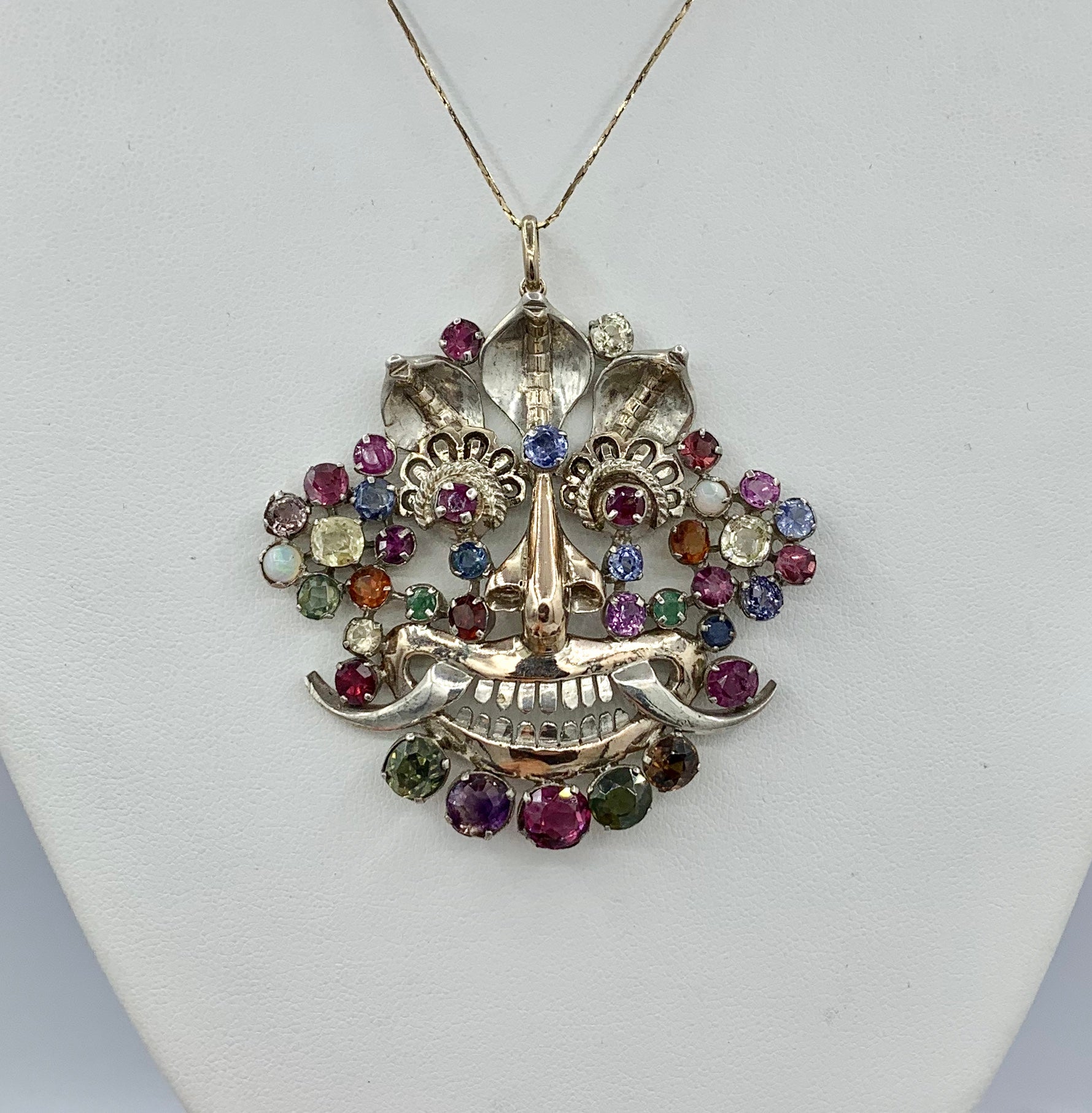 Il s'agit d'un absolument magnifique pendentif masque en saphir naturel multicolore et opale en argent et or 14 carats.  Ce bijou extraordinaire est serti de saphirs multicolores d'une grande beauté, extraits de mines naturelles.  Les quatre grands