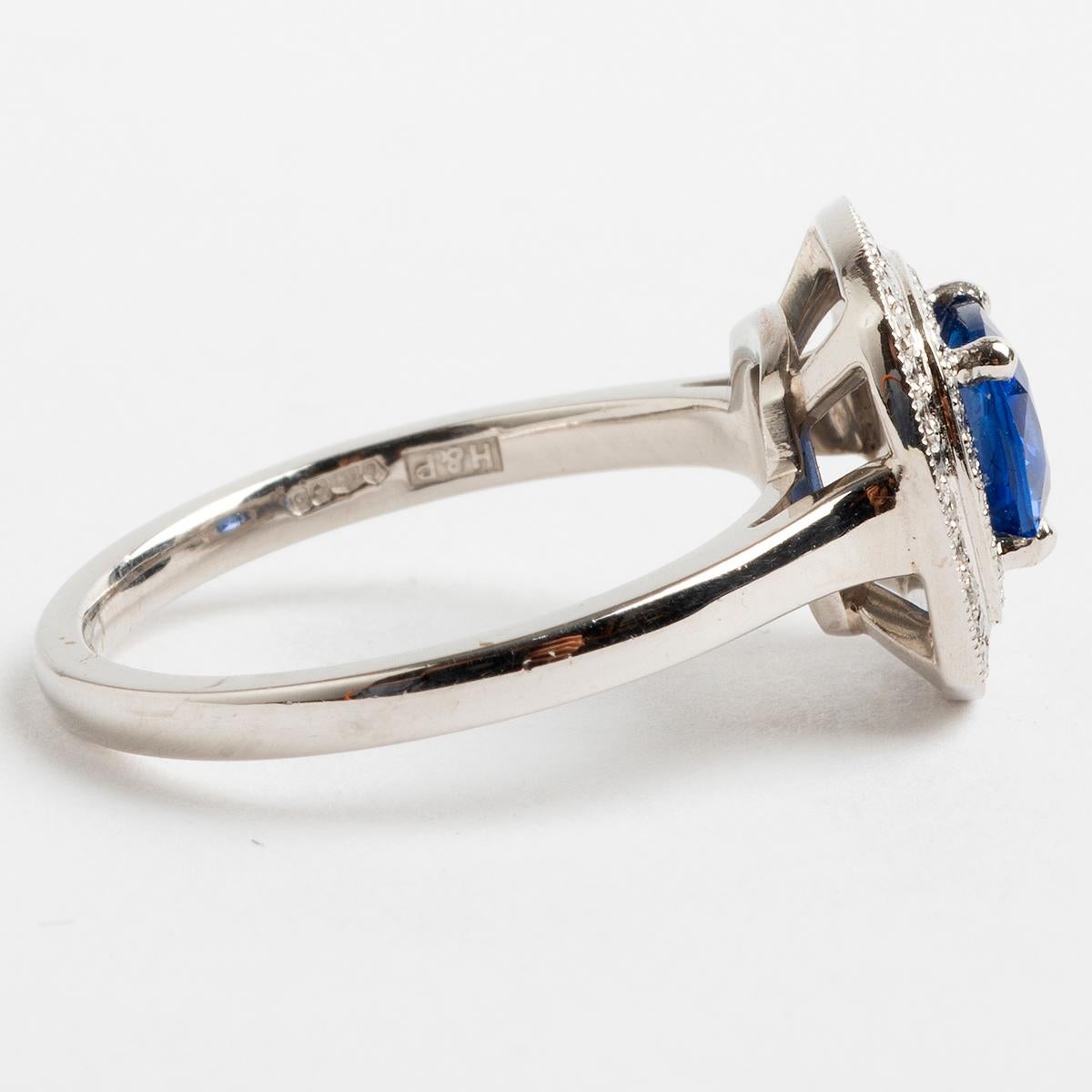 Une fabuleuse bague en platine sertie d'un halo, centrée d'un grand saphir de très haute qualité (environ 1,04 carat) et entourée de diamants pavés dans un double halo (environ 0,19 carat au total), cette bague serait l'ultime déclaration. La taille