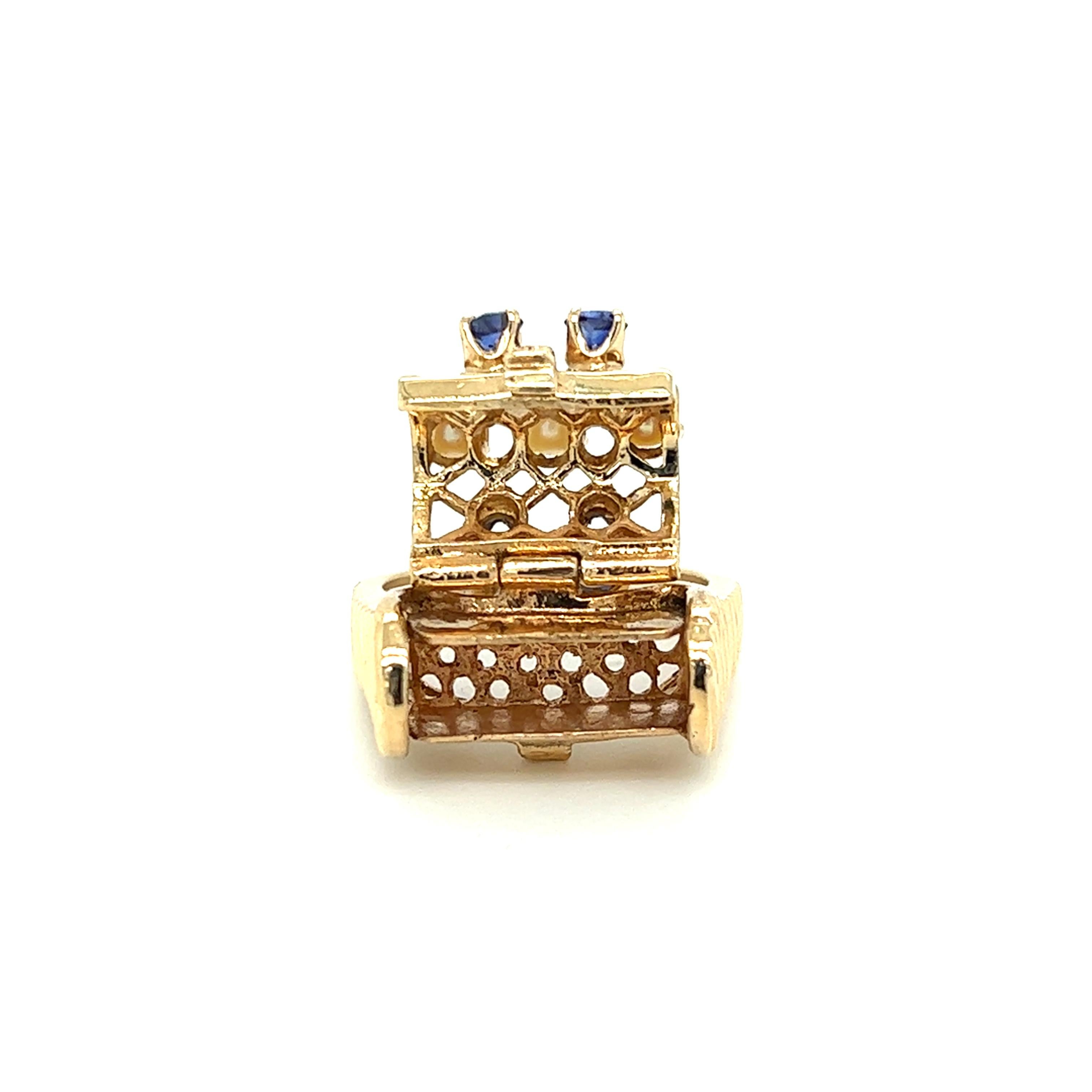 One 14 karat yellow gold poison/pill box ring adorned with four (4) 3mm blue sapphires and three (3) 4mm round cultured pearls. The secret box opens well and will stay closed.  The ring is a finger size 6 and can be resized. Sizing is not included. 
