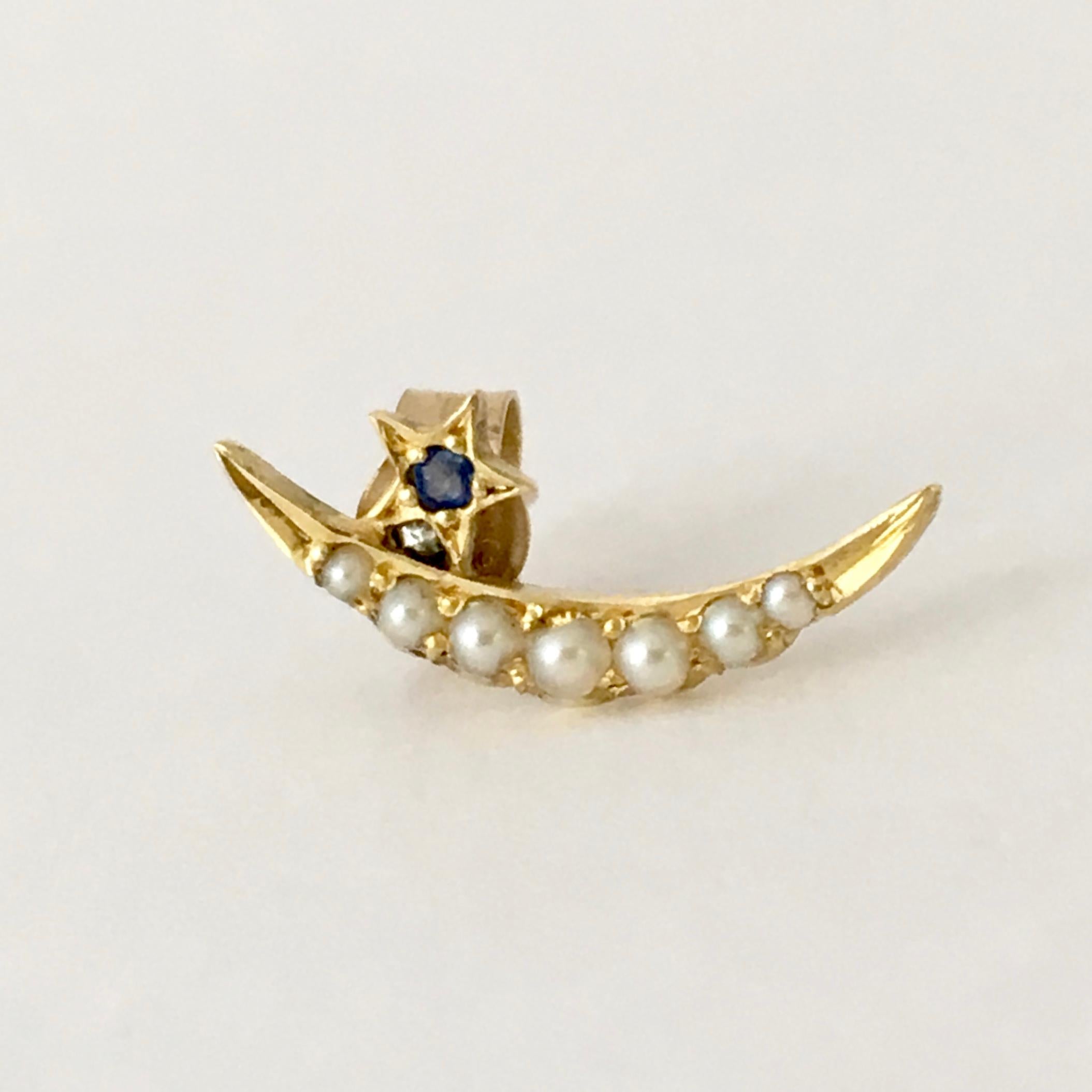 This dainty 9ct gold single earring combines seven seed pearls with a tiny sapphire, perfectly reflecting the night sky. The condition is remarkable for such a delicate piece and the celestial theme is particularly on trend at the moment. 

The moon