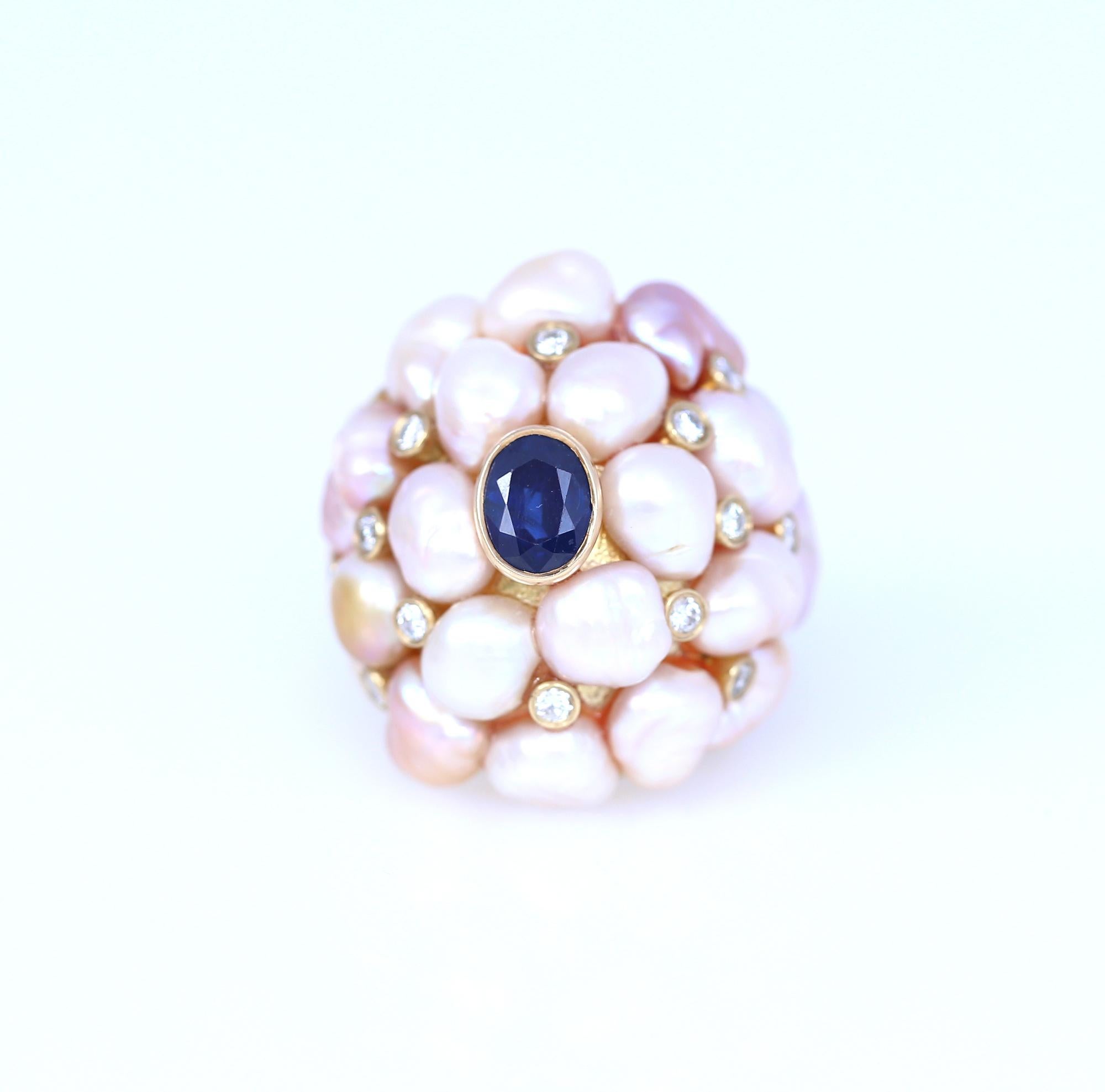 Fine Pearls of different shapes and Fine Diamonds are put together on top of a 14K Yellow Gold ring. With a fine deep blue Sapphire in the middle. Very bold and unmistakably 70-es design. 
Now sustainability is gaining momentum in the jewelery