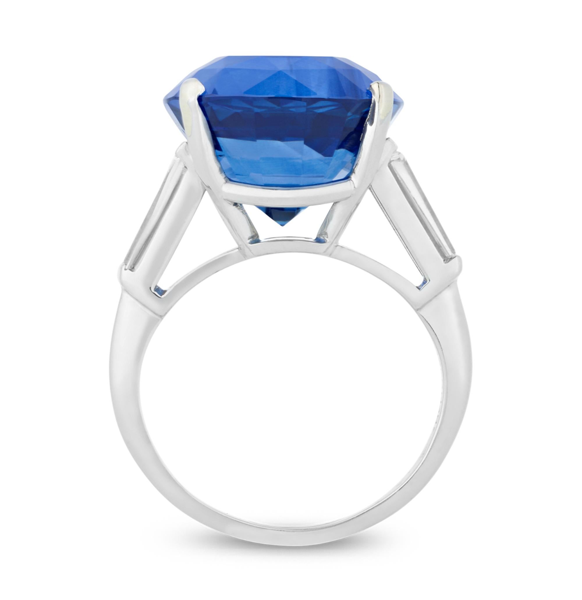 The stunning cushion cut sapphire at the center of this Art Deco-style ring weighs an astonishing 16.55 carats. Displaying the ideal royal blue hue, the sapphire is AGL-certified as originating in the prestigious mines of Madagascar. Shining with
