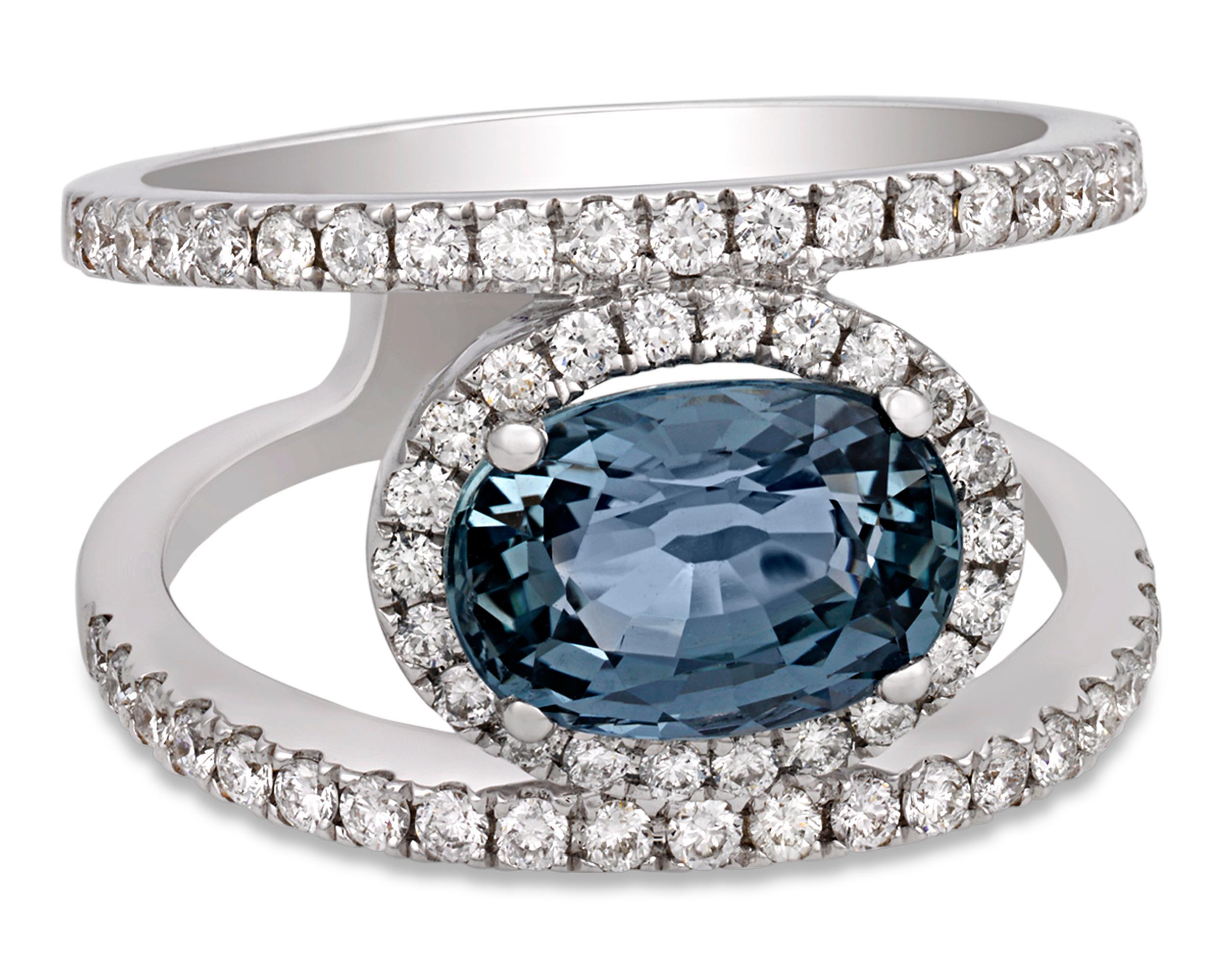 The exceptional 2.20-carat sapphire at the center of this one-of-a-kind ring exhibits a lovely soft grayish blue coloring. The natural beauty of this oval-shaped stone is highlighted by a unique double band setting studded with 0.39 carat of white