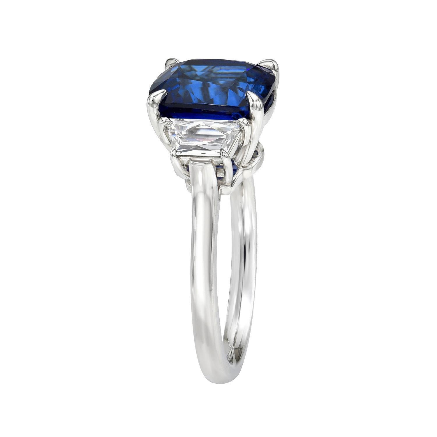 Magnifique saphir bleu royal en coussin de 5,03 carats, bague en platine à trois pierres, ornée d'une paire de diamants trapèzes de taille française de 0,58 carats, de couleur D-E et de pureté VS1.
Taille 6. Le redimensionnement est gratuit sur