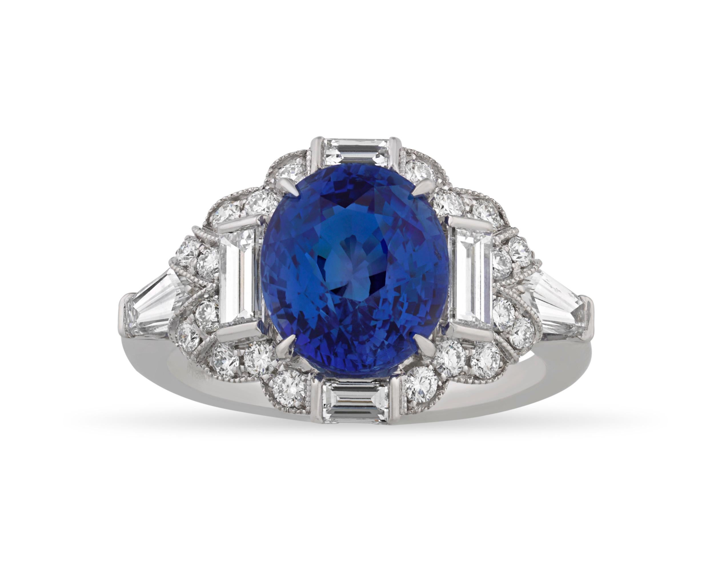 An exquisite, vibrant blue sapphire weighing 3.52 carats is mounted in this ring by celebrated American jeweler Raymond Yard. The colorful gem is complemented by 1.18 carats of white diamond accents in round, baguette and reverse taper baguette