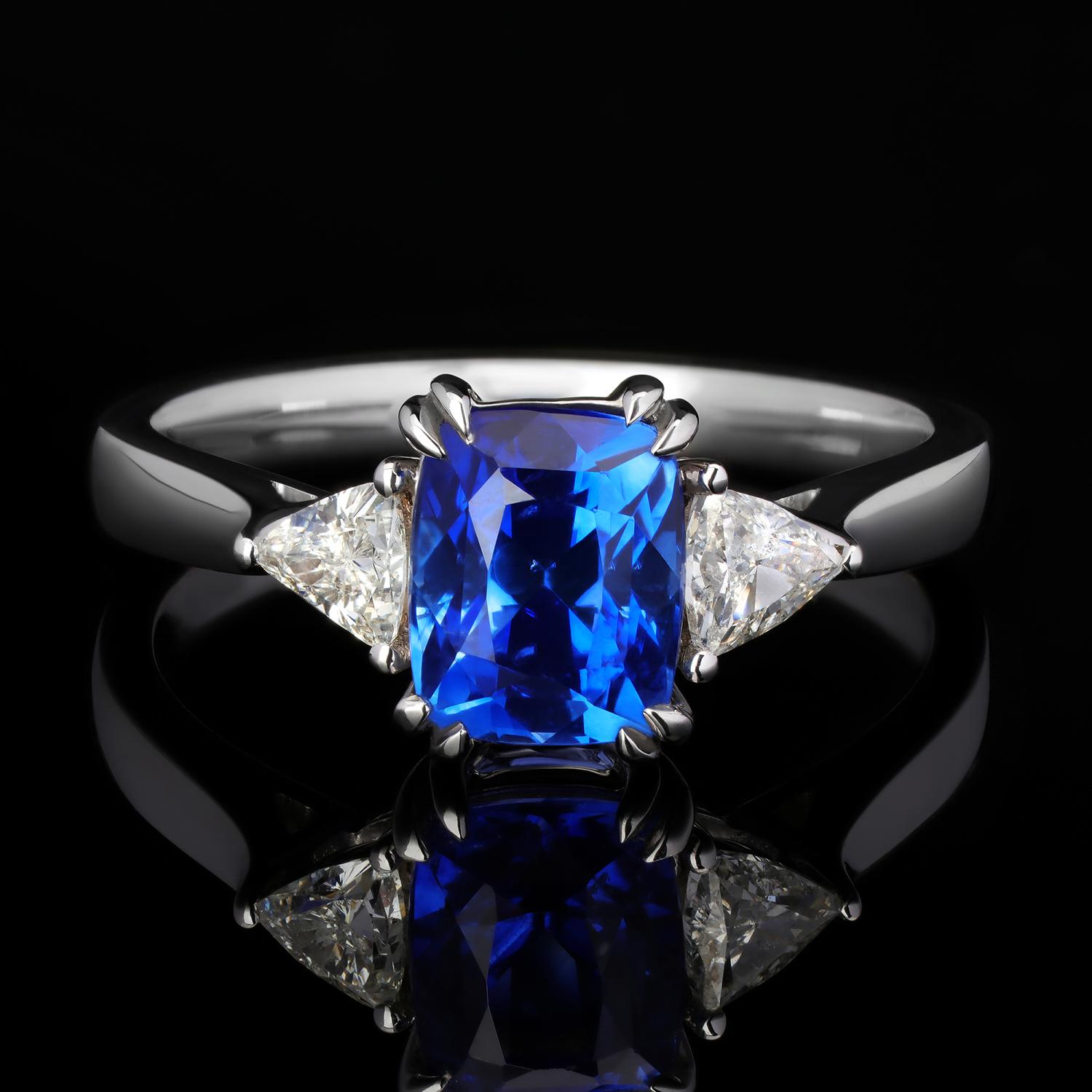 This contemporary custom made engagement ring/promise ring features a unique interplay of naturally beautiful gemstones. An Sapphire is securely prong set sideways in the center, exhibiting an incredible play-of-color. This hand-cutted Sapphire is