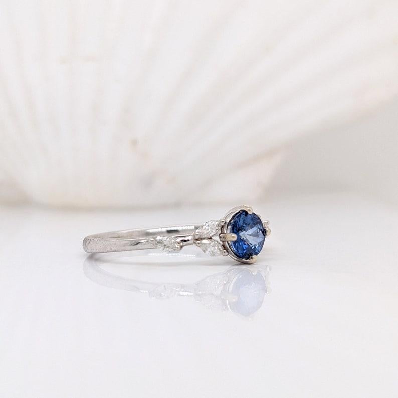 This lovely blue Sapphire ring has marquis diamond accents giving it a leafy, nature inspired design. This ring features a royal blue Ceylon Sapphire in 14k white Gold. A unique ring design perfect for an eye catching engagement or anniversary. This