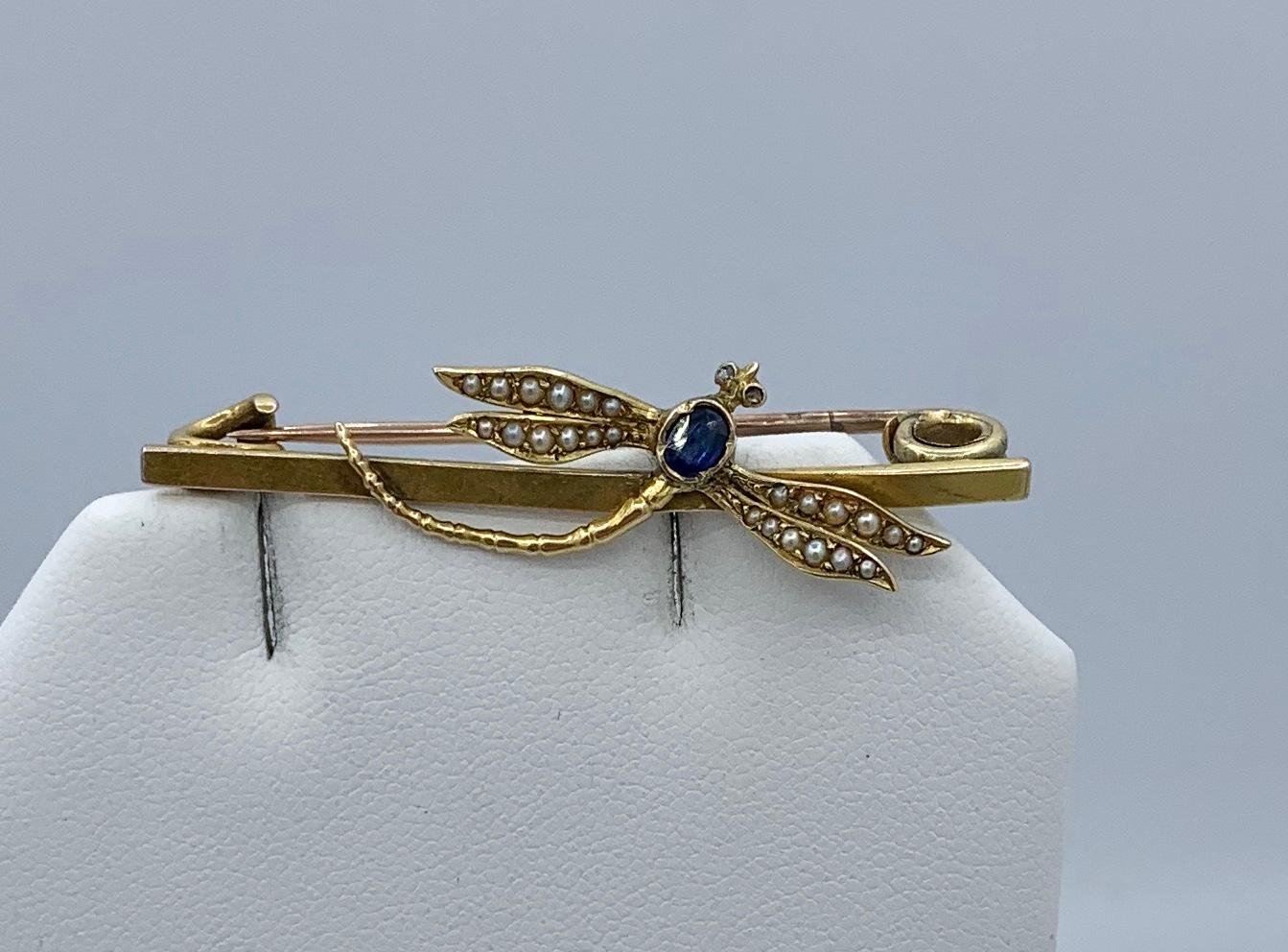 This is a stunning Art Nouveau - Art Deco Dragonfly Insect Brooch Pin with an oval faceted natural mined blue Sapphire of great beauty.  The eyes are set with Rose Cut Diamonds.  The wings are adorned with seed pearls.  The brooch is 14 Karat Gold. 