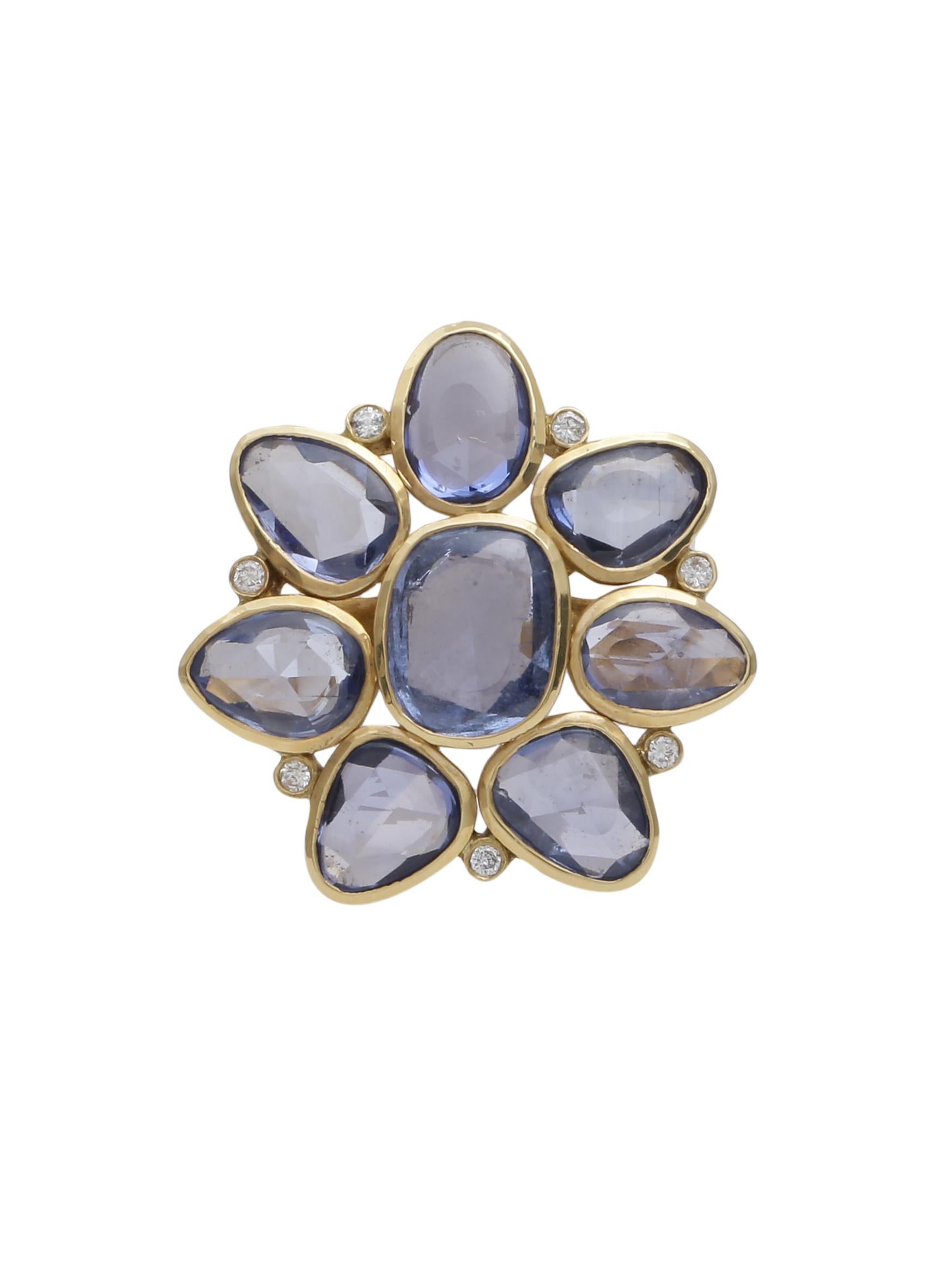 Blue Sapphires rosecuts and Diamonds closely set in a way to give a floral design. The asymmetric Sapphires are set in gold bezels and are given shape.  The ring is all Handcrafted in 18K Yellow Gold. The ring has 6.35 carats Sapphires, 0.07 carats