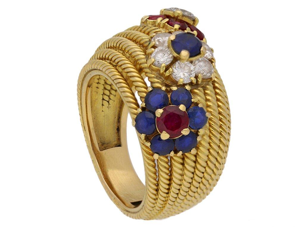 Ruby, sapphire and diamond dress ring attributed to the Van Cleef & Arpels Hawaii collection. Diagonally set with three florette form clusters consisting of seven round brilliant cut natural unenhanced sapphires in open back claw settings with a