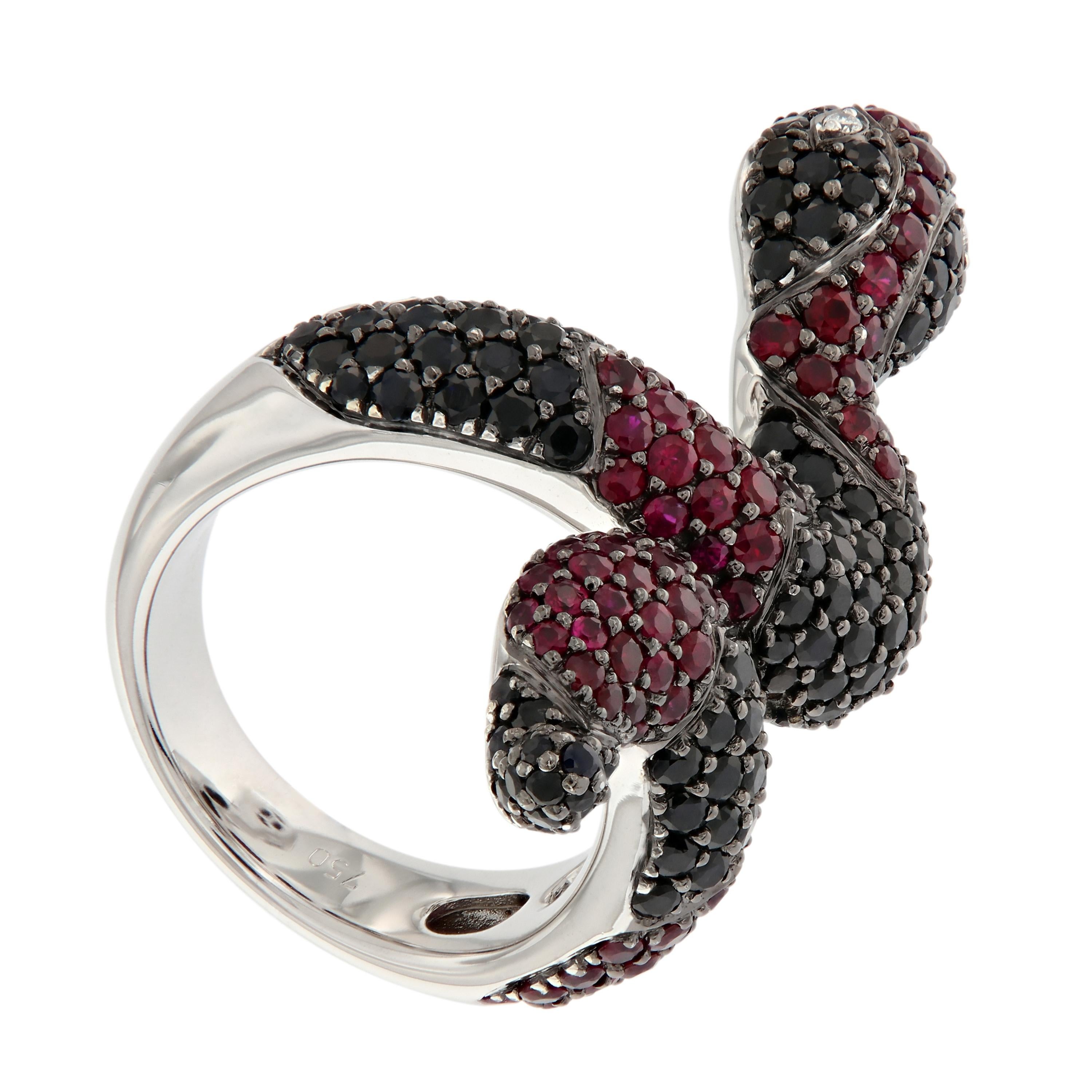 Fashion serpent ring with an exotic edge is crafted in 18k white gold. The coiled serpent design is detailed with black sapphires, rubies and diamond eyes. Ring size 6.5. Weighs 20 grams. 

Black Sapphire 3.48 cttw
Ruby 1.76 cttw
Diamond 0.20 cttw