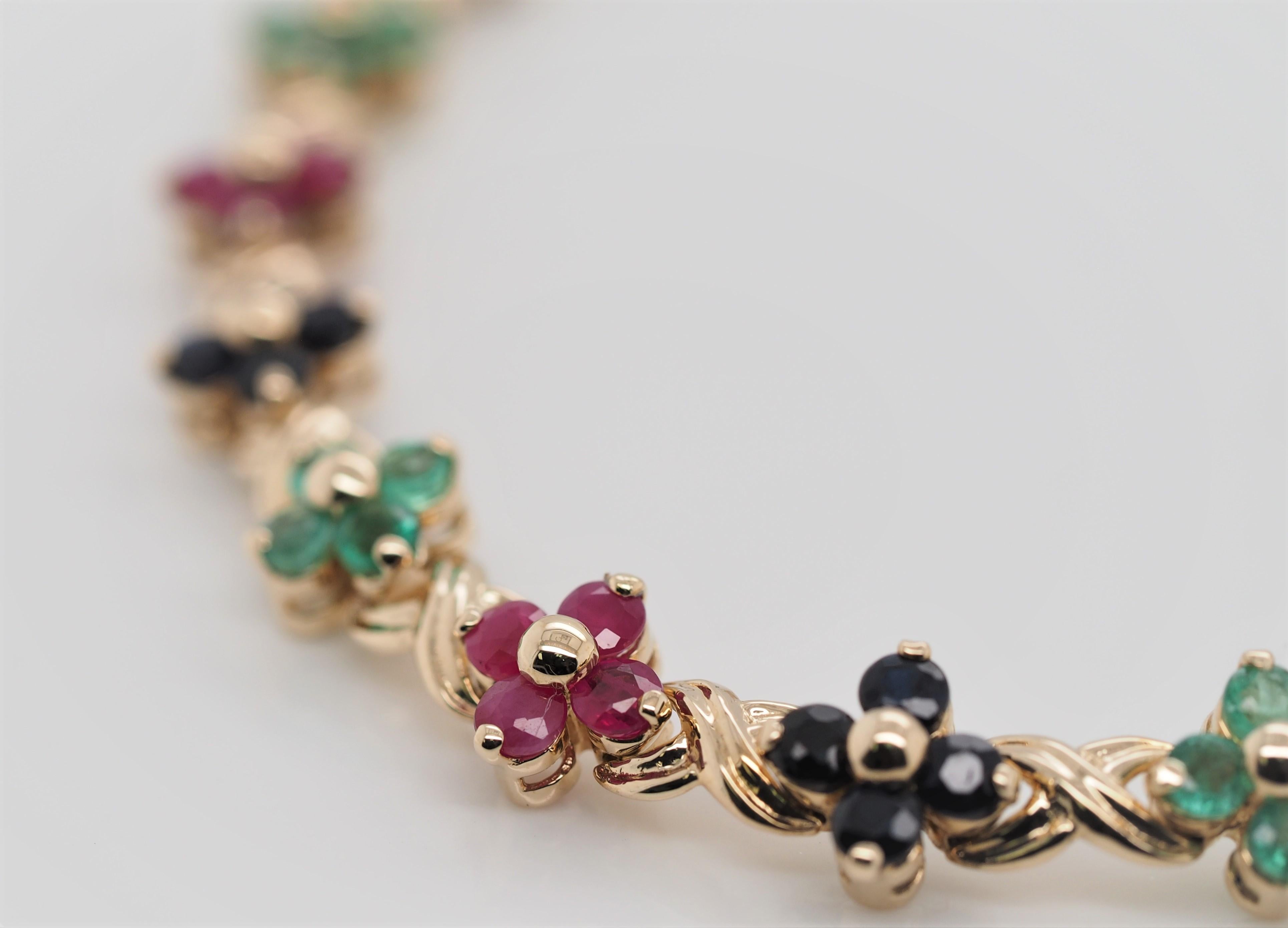 14 karat yellow gold flowers link bracelet with Blue sapphires, Red Rubies and Green Emeralds.
The bracelet is 7