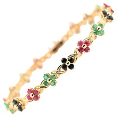 Gliederarmband aus 14 Karat Gelbgold mit Saphiren, Rubin, Smaragden und Blumen