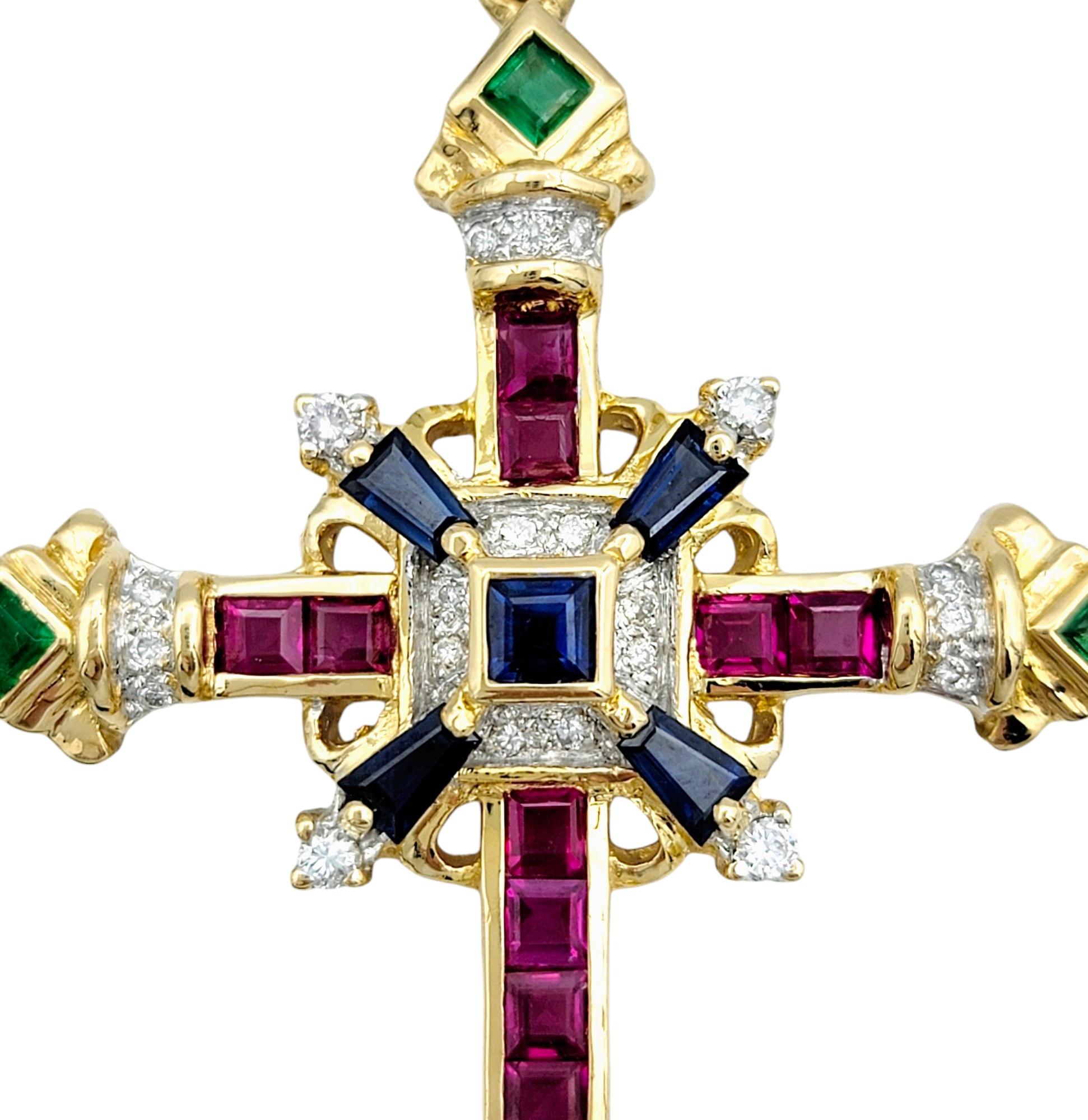 This beautiful cross pendant, crafted in luxurious 18 karat yellow gold, is adorned with a vibrant array of gemstones. Set against the rich backdrop of yellow gold, the sapphires, rubies, emeralds, and diamonds create a stunning mosaic of colors