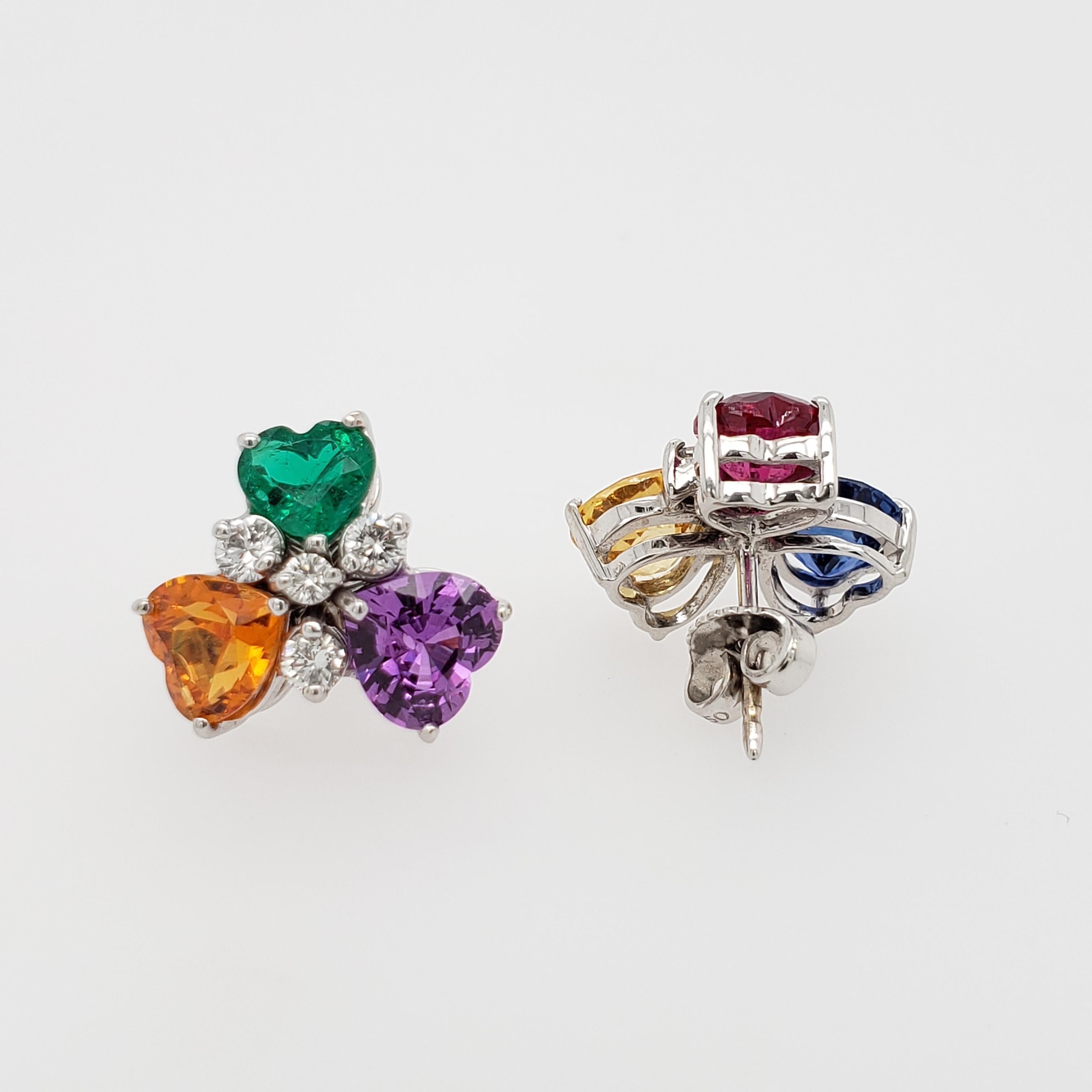18kt White Gold stud earrings. Multi-colored sapphires, emerald, ruby, & diamonds. The heart shaped blue sapphire weighs 1.25 carats, the yellow sapphire weighs 1.29 carats, the orange sapphire weighs 1.29 carats, the purple sapphire weighs 1.63