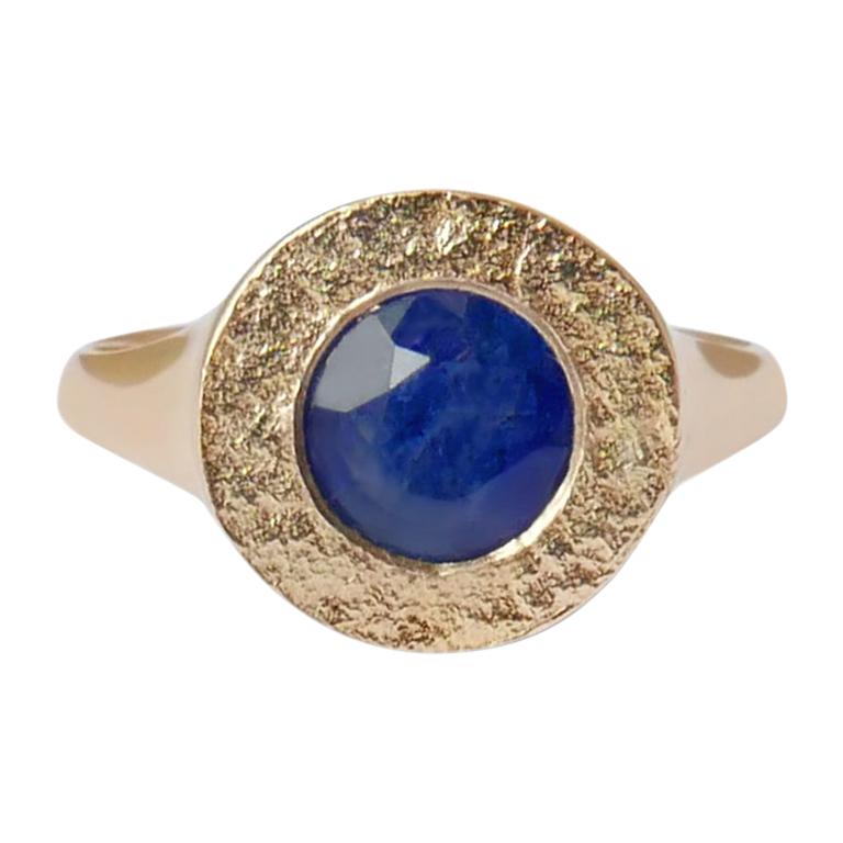 This textured signet ring features a natural Sri Lankan sapphire embedded in a shimmering texture crafted in solid 14-carat gold.  The ring is finished with a high polish on the sides and band for a comfortable fit.  This ring is a UK size M