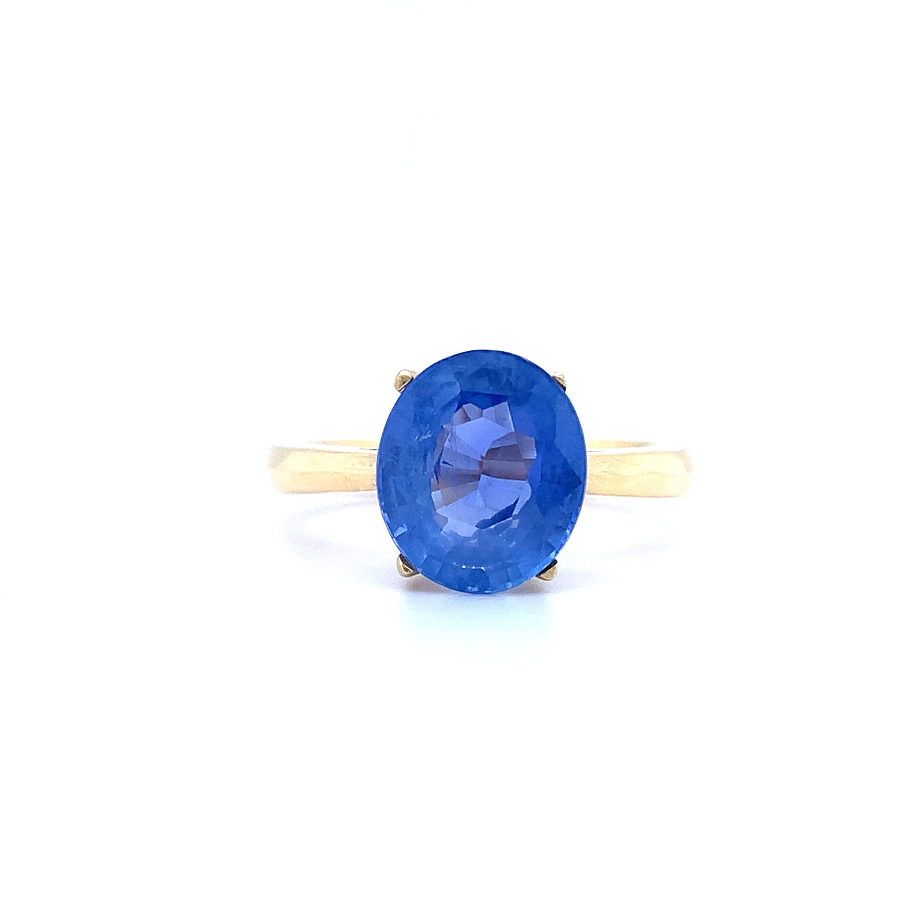 Este precioso anillo de compromiso tiene un impresionante zafiro ovalado de aproximadamente 1,65 ct engastado en oro amarillo de 18k. El estilo de engaste solitario resalta la magnífica piedra principal de forma ovalada, mientras que la banda de 2