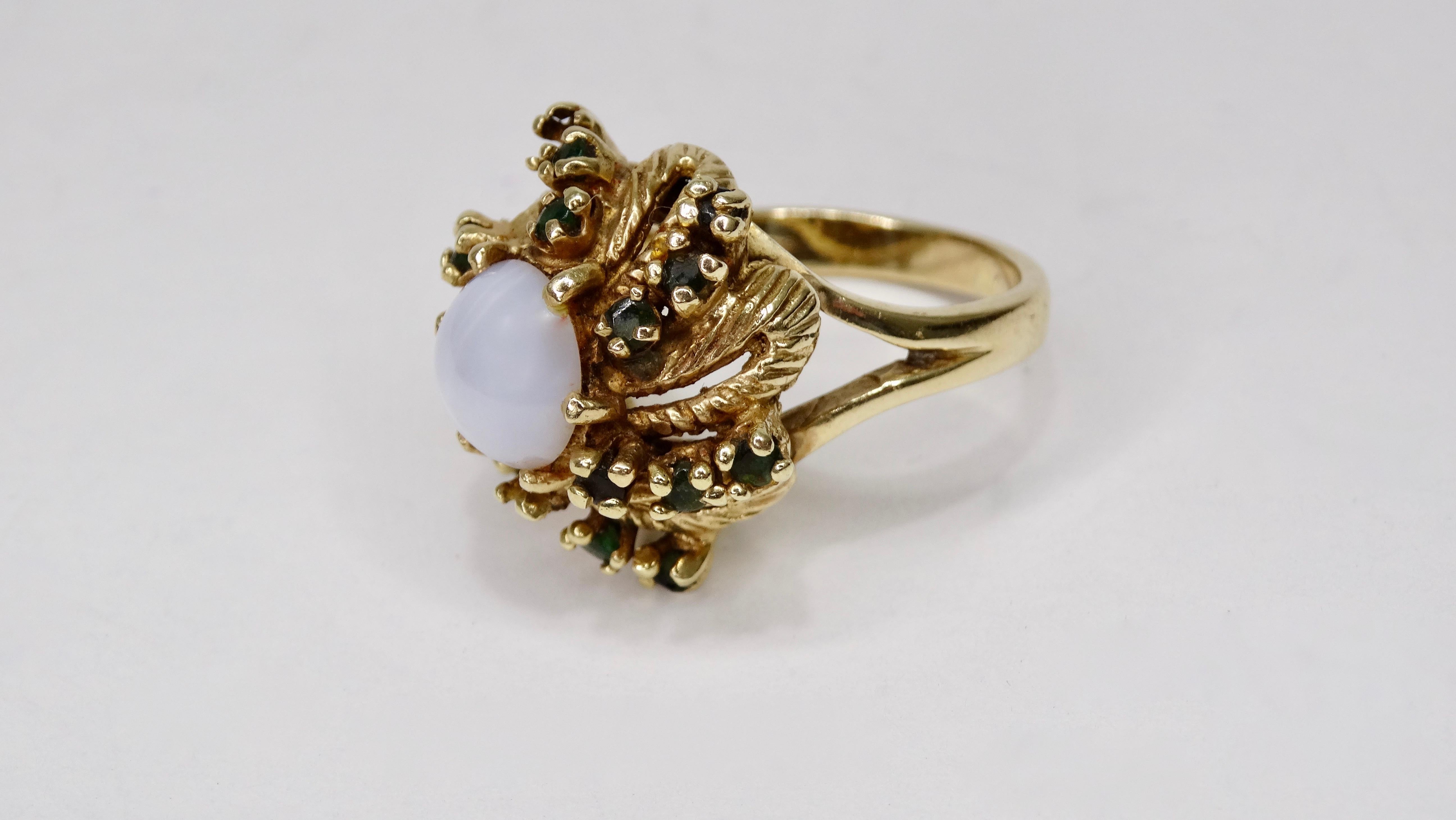 Beautiful mid-20th century 14k Gold ring featuring a Cabochon cut 4 carat Star Sapphire center stone with round cut Emeralds spiraling out. Please note two of the Emeralds are missing from the prong setting. Ring is a size 7 and weighs 10.61g total.