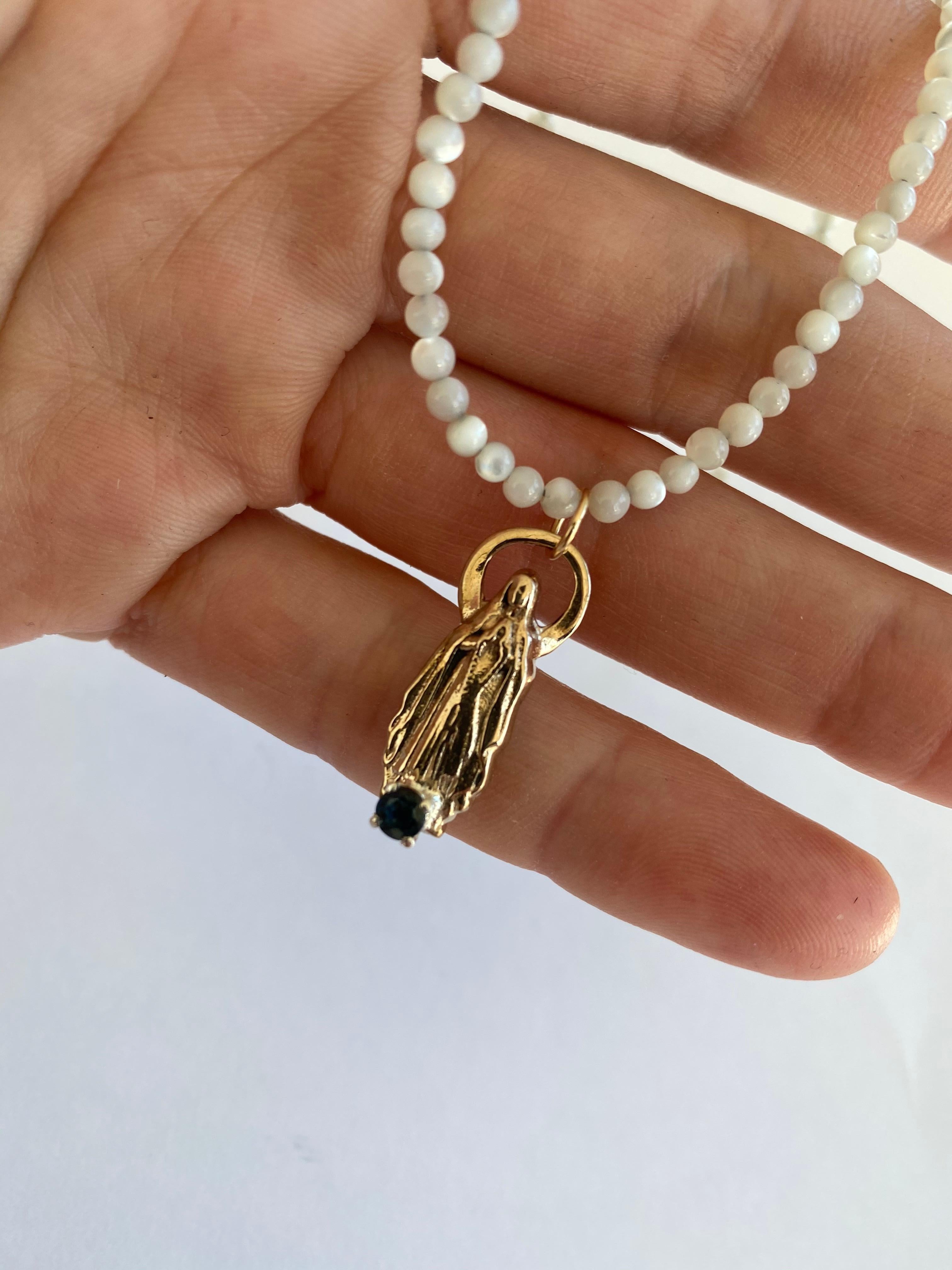 Sapphire Virgin Mary White Bead Necklace J Dauphin

Exclusive piece with Virgin Mary pendant and a Blue Sapphire set in a gold prong on a Bronze Figurine pendant. Bead Necklace is 16' long.

Symbols or medals can become a powerful tool in our