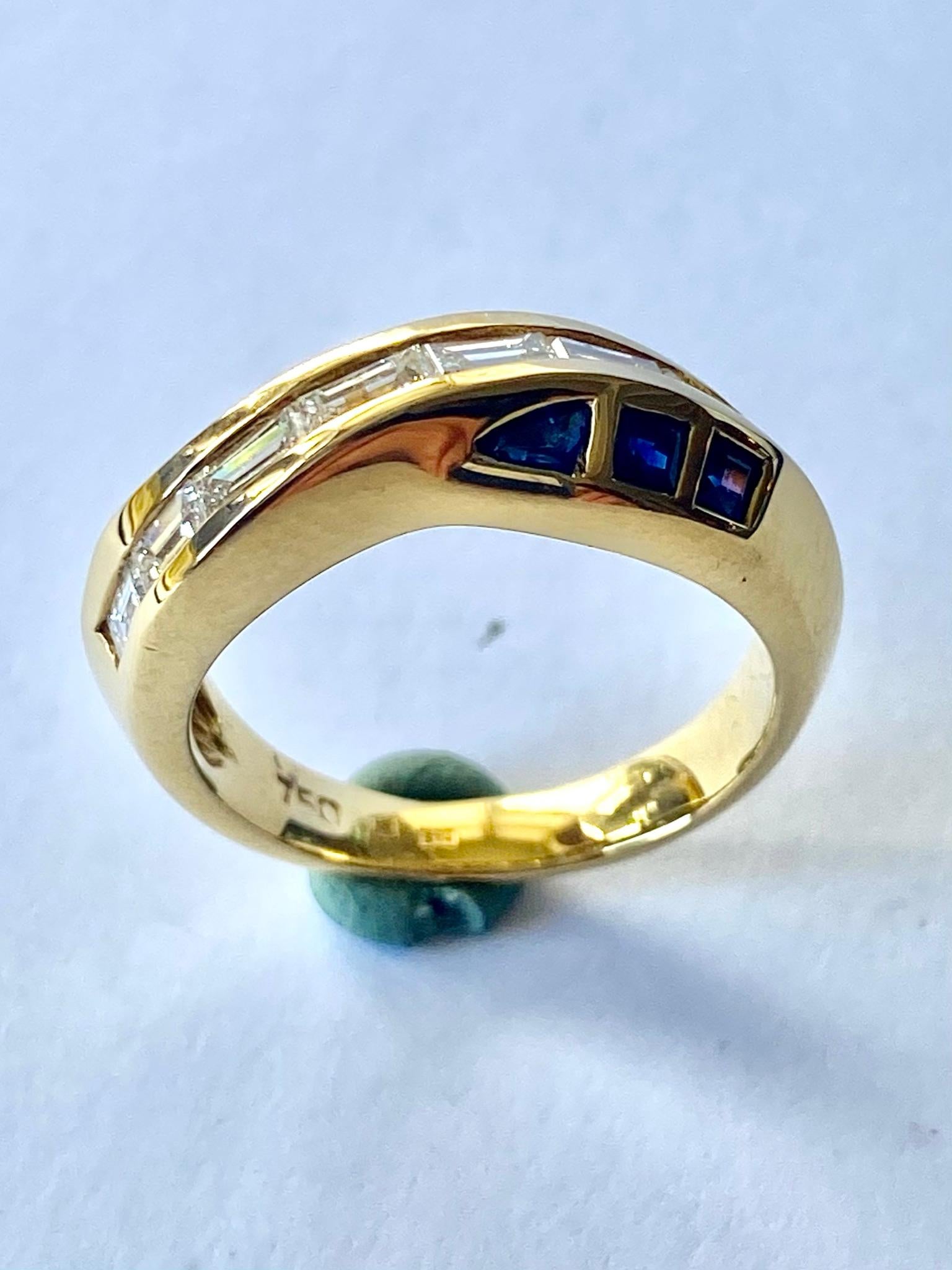 One (1) 18 Karat Yellow Gold Ring, Stamped  750 and SV+ = Vaessen jeweler Holland
set with:
Six (6) Triangle Cut Sapphires adn Seven (7) Baquette Cut Diamonds
Sapphires 0.50 ct.
Diamaonds: 0.60 ct. VVS - F-G
Total Wreight: 6.92 grams.
Sice of the