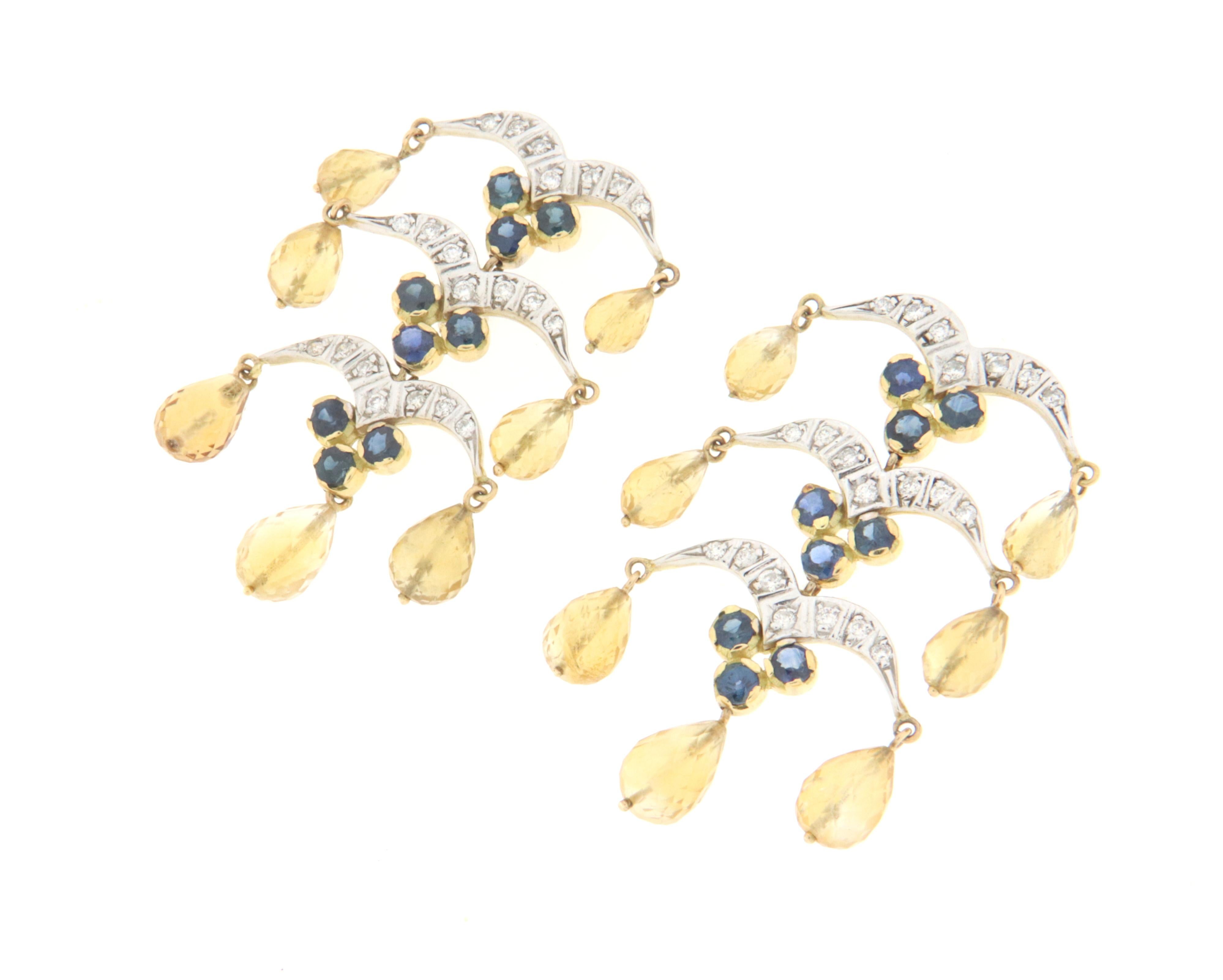 Eleganter Ohrring, vollständig von Hand aus 18 Karat Weiß- und Gelbgold gefertigt, besetzt mit Saphiren, Diamanten und birnenförmigen Anhängern aus facettiertem gelbem Citrin.
Ein Jewell, das auf das Läppchen einer Frau wirkt, das zu jeder Art von