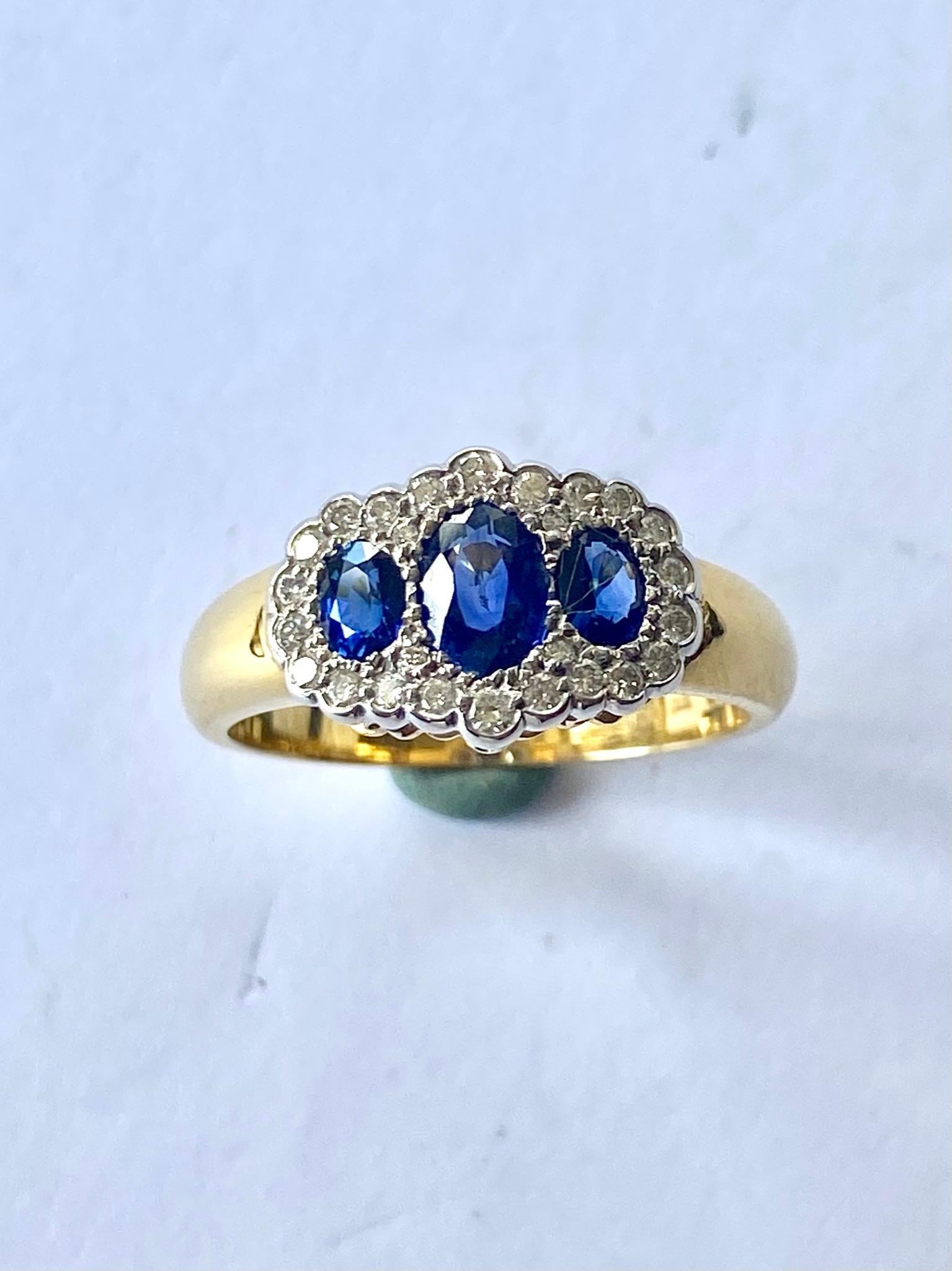 One (1) 18K. Yeloow and White Gold Ring, Stamped 750 with London Stampes (UK)
Set with:
Three (3) oval mixed Cut Natural Sapphires:  1.01 ct (deep blue)
Twenty Six (26) round briljant Cut natural Diamonds = 0.20 ct VS - F G
Classic 3 stone