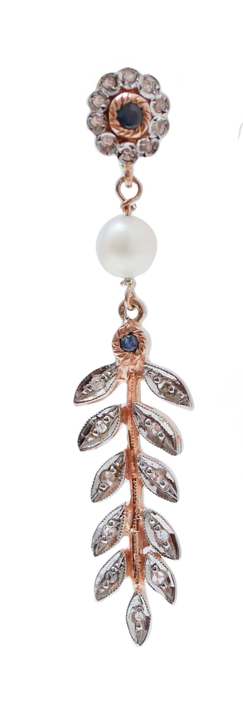 Fantastic earrings in 9 kt rose gold and silver structure mounted with a flower of diamonds and a central sapphire in the upper part. In the middle, a pearl and, below, a sapphire and a  rain of leaves studded with diamonds.
These earrings were