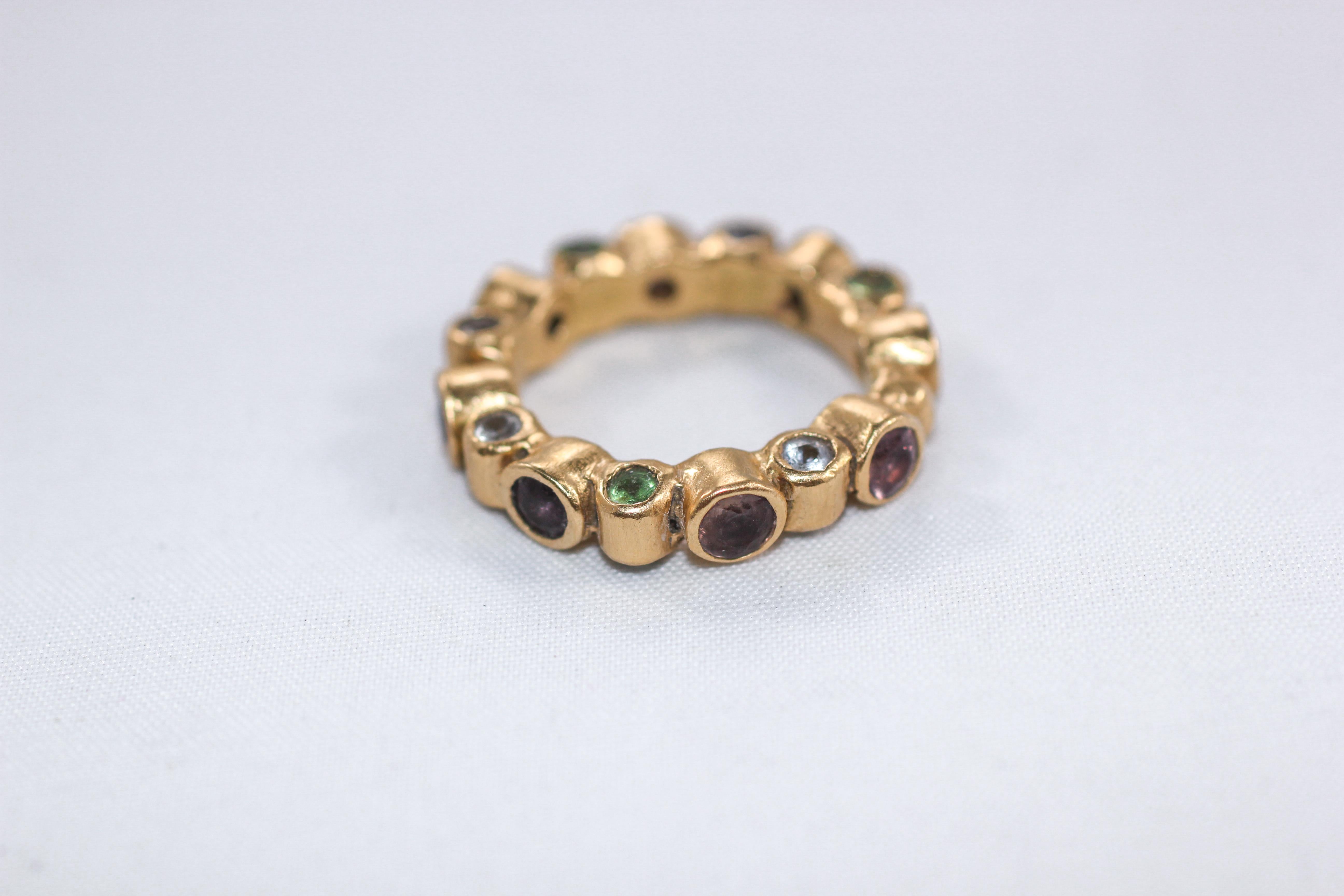 Anneau cylindrique. Une bague de mariage, une bague de cocktail ou une bague de mode, sertie sur les trois côtés. Ce Whiting concerne la bague sertie de saphirs roses et blancs, de tanzanites et de tsavorites, pierres taillées en brillant. Comme une