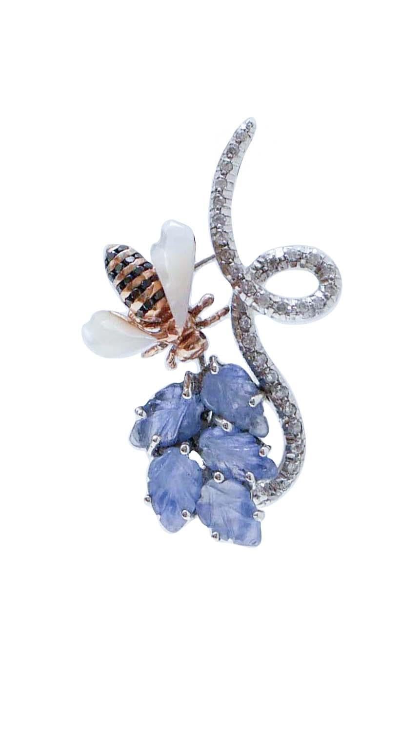 Particulares pendientes colgantes de estructura de platino montados con diamantes y hojas de zafiros. Unidas a ellas, dos abejas de oro rosa de 14 quilates montadas con diamantes negros en el cuerpo y piedras blancas en las alas.
Estos pendientes