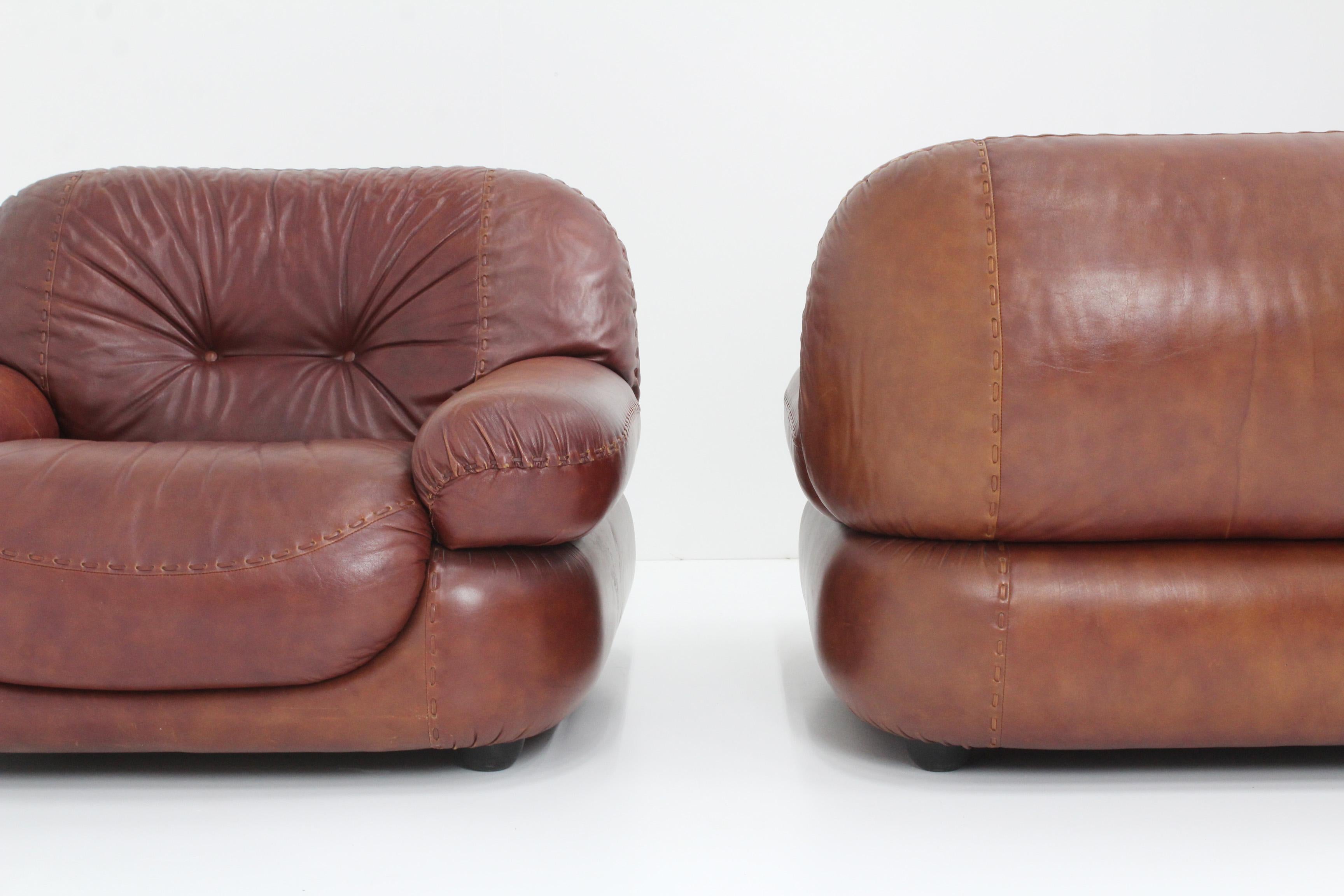 A set of 2 Italian Lounge Chairs in Leather designed by Sapporo for Mobil Girgi in the 1970s. The chairs are extremly comfortable and well designed, high quality italian design. Original burgundy brown leather upholstery, beautiful patina. The seats