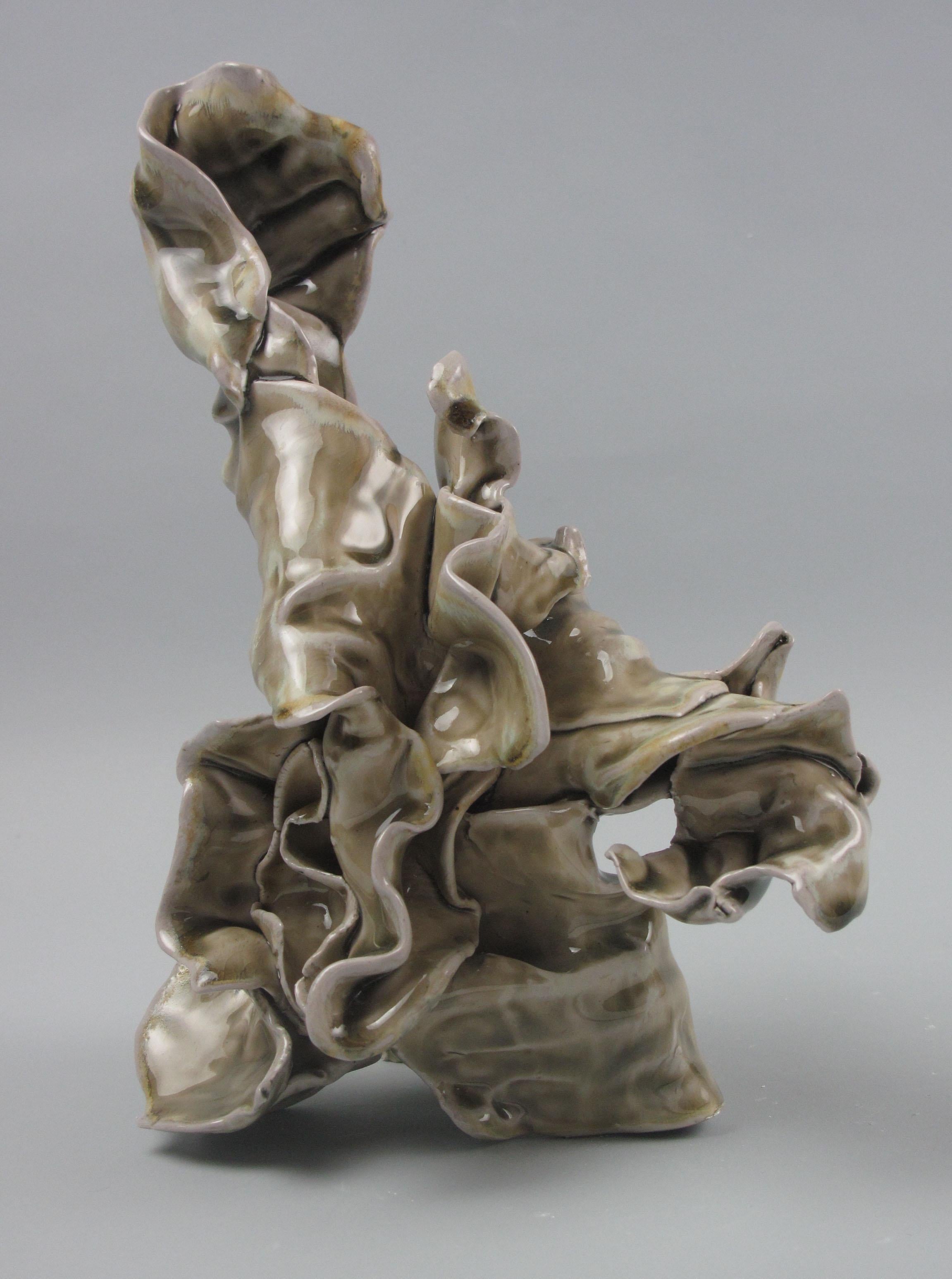 Sara Fine-Wilsons ”Carry” is a gestural 11 x 7 x 6 inch ceramic sculpture in pale celadon green with accents of warm yellow, brown and white. In this graceful and evocative sculpture individual slab elements are assembled, layered in glaze and soda